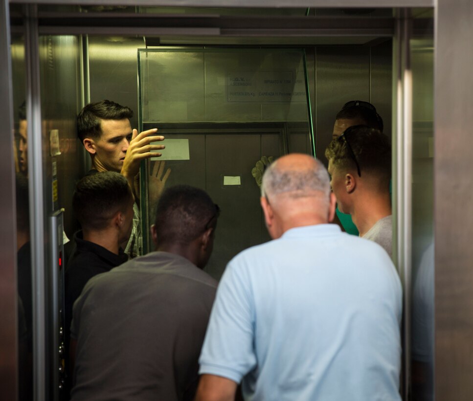 Marines and Sailors with the second iteration of SP-MAGTF Africa 14 squeeze into an elevator with a display case inside of Ursino Castle in the heart of Catania, Italy, July 24, 2014. This was the first time a group of US service members have worked inside this historic landmark. (U.S. Marine Corps photo by Cpl. Shawn Valosin)