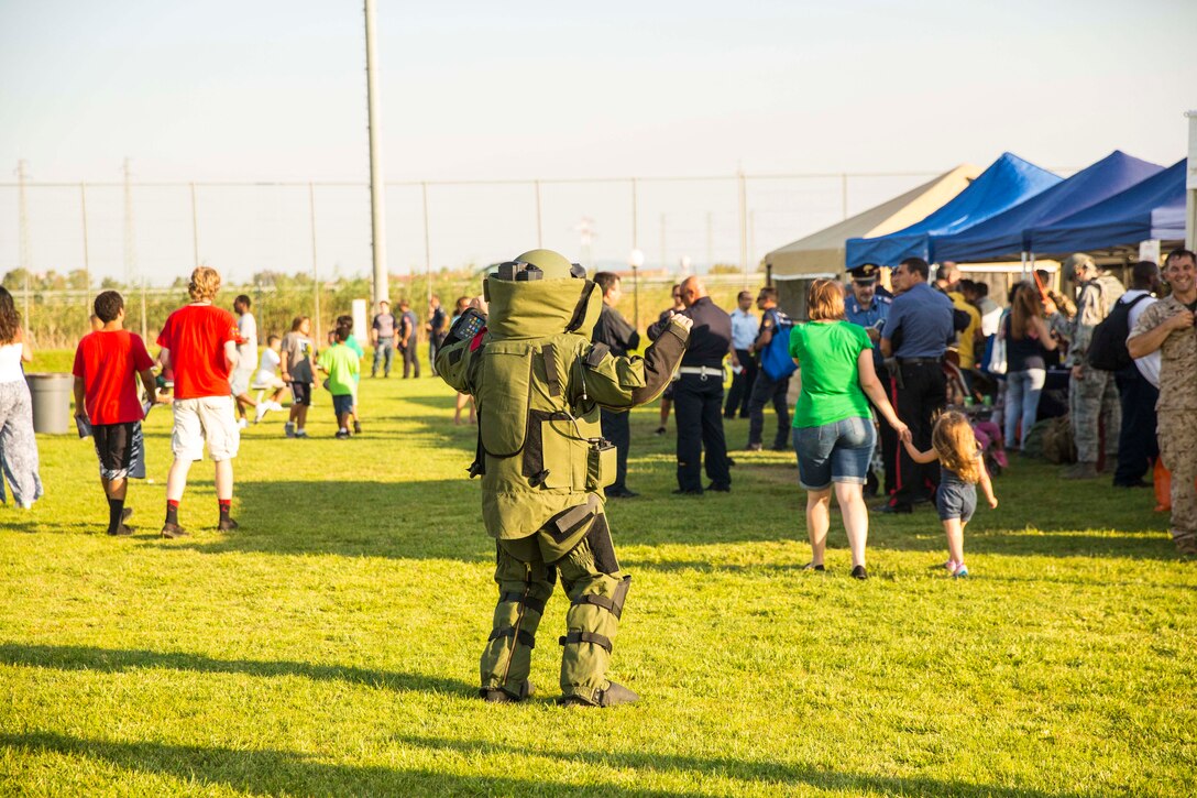 A Marine with the second iteration of SP-MAGTF Africa 14 dances while wearing a bomb suit at the National Night Out event aboard Naval Air Station Sigonella, Italy, Aug. 5, 2014. Marines and Sailors with SP-MAGTF AF participated in the event with a static display of weapons, an Explosive Ordnance Disposal robot, and two vehicles organic to the Marine Corps. SP-MAGTF Africa continues to build relationships with the community while simultaneously strengthening U.S. Africa Command and U.S. Marine Corps Forces Africa’s ability to assist partner nations in addressing security challenges in the region. (U.S. Marine Corps photo by Cpl. Shawn Valosin)