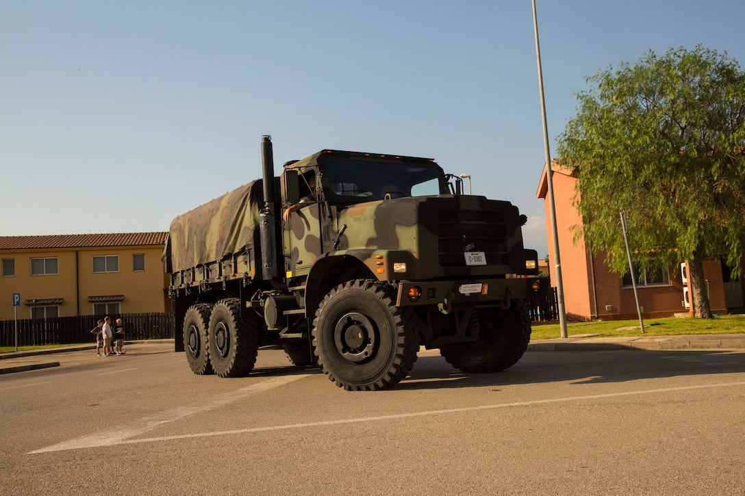 A seven-ton truck with Marines drive through the Marinai government housing aboard Naval Air Station Sigonella, Italy, during the National Night Out event Aug. 5, 2014. Marines and Sailors with the second iteration of SP-MAGTF Africa 14 participated in the event with a static display of weapons, an Explosive Ordnance Disposal robot, and two vehicles organic to the Marine Corps. SP-MAGTF Africa continues to build relationships with the community while simultaneously strengthening U.S. Africa Command and U.S. Marine Corps Forces Africa’s ability to assist partner nations in addressing security challenges in the region. (U.S. Marine Corps photo by Cpl. Shawn Valosin)