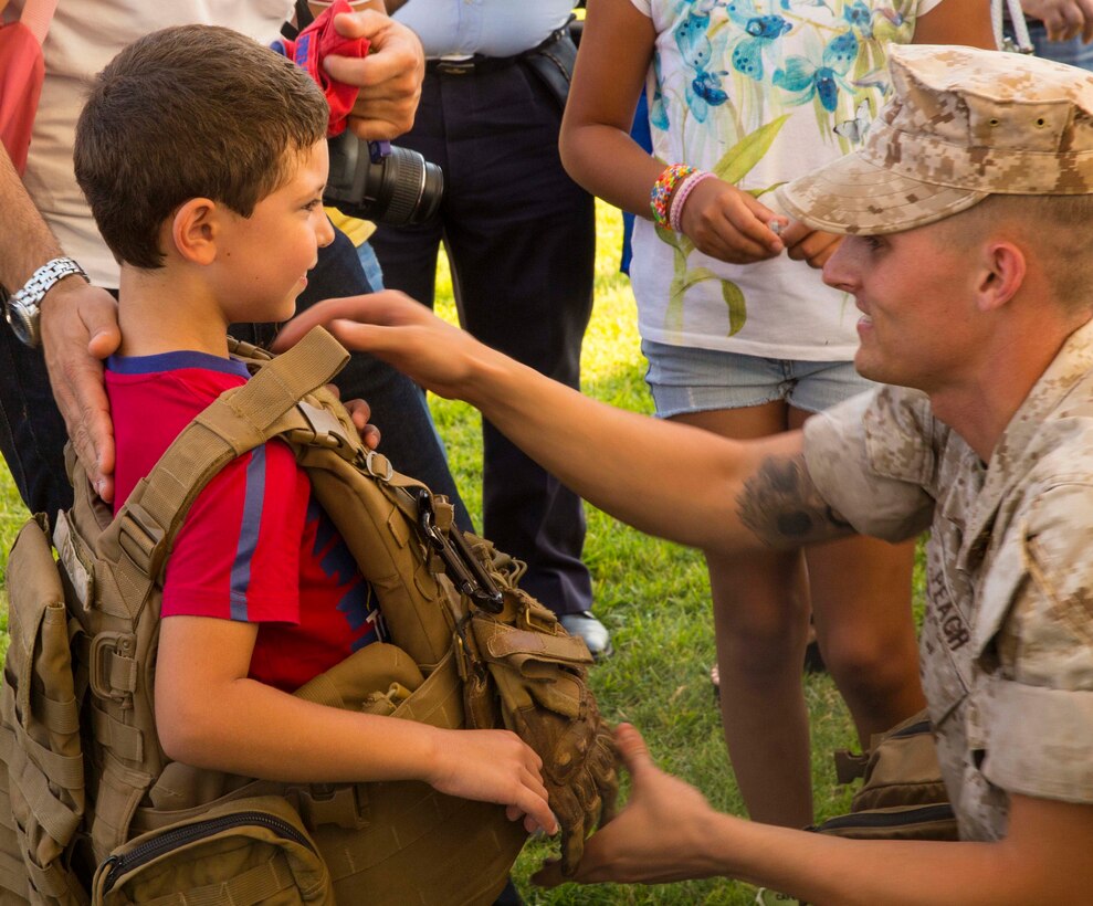 Cpl. Kevin Peach helps a child don a FLAK Jacket at the National Night Out event aboard Naval Air Station Sigonella, Italy, Aug. 5, 2014. Marines and Sailors with the second iteration of SP-MAGTF Africa 14 participated in the event with a static display of weapons, an Explosive Ordnance Disposal robot, and two vehicles organic to the Marine Corps. SP-MAGTF Africa continues to build relationships with the community while simultaneously strengthening U.S. Africa Command and U.S. Marine Corps Forces Africa’s ability to assist partner nations in addressing security challenges in the region. (U.S. Marine Corps photo by Cpl. Shawn Valosin)