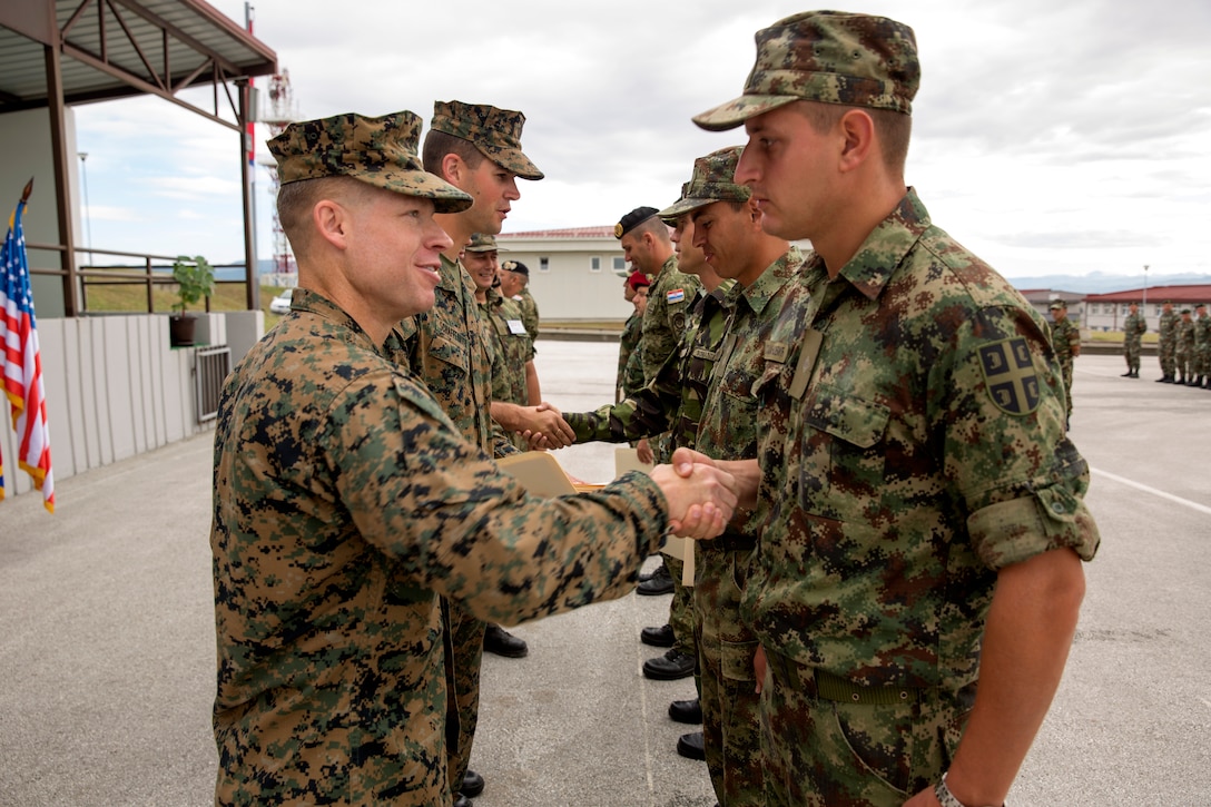 United States Marine Corps Lt. Col. Trevor Hall, the commanding officer of Black Sea Rotational Force 14.2, and 3rd Battalion, 8th Marine Regiment, hands out certificates and congratulates the participating nations’ platoon commanders for completing non-lethal training during exercise Platinum Wolf 14’s closing ceremony aboard South Base, Serbia,  July 11, 2014. This is the first iteration of the Platinum Wolf exercise, hosted by Serbia, with members of the Serbian, Croatian, Bulgarian, Romanian, Azerbaijani, Macedonian and United States militaries participating in the exercise. The exercise focused on non-lethal system training and peacetime operations in order to foster greater interoperability with each other while promoting peace and prosperity in the Black Sea, Balkan and Caucasus regions of Eastern Europe. (Official Marine Corps photo by Lance Cpl. Scott W. Whiting, BSRF PAO/ Released)