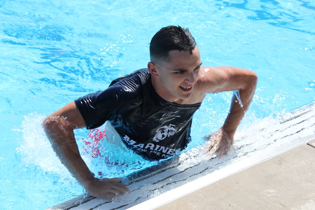 Lance Cpl. Alexander Vasquez, disperser at the Finance Branch, jumps out of the pool after beating three other Marines in the “Frozen T-Shirt” contest during Headquarters and Service Battalion’s “Pool Bash” at Quantico 50M Pool on July 28.
