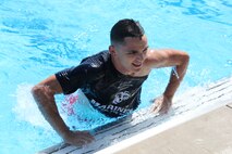 Lance Cpl. Alexander Vasquez, disperser at the Finance Branch, jumps out of the pool after beating three other Marines in the “Frozen T-Shirt” contest during Headquarters and Service Battalion’s “Pool Bash” at Quantico 50M Pool on July 28.