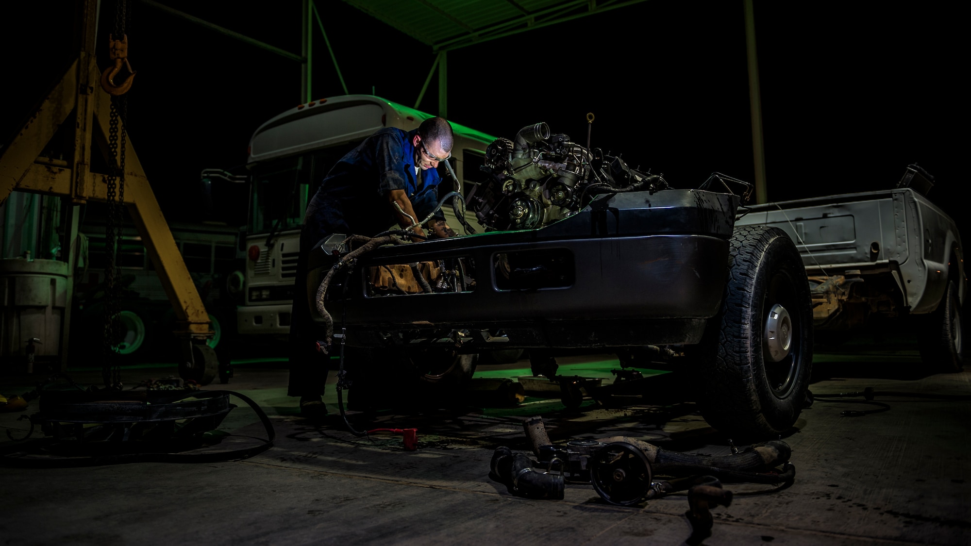 Senior Airman Christopher Moore removes the engine of a truck July 18, 2014, at an undisclosed location in Southwest Asia. Moore, a vehicle mechanic with the 386th Expeditionary Logistics Readiness Squadron, deployed from the 86th Vehicle Readiness Squadron, Ramstein Air Base, Germany in support of Operation Enduring Freedom. (U.S. Air Force photo/Staff Sgt. Jeremy Bowcock)