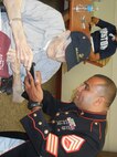 Staff Sgt. Alvaro Mena, Installation Personel Administration Center, shows pictures he recently took at Okinawa to to retired Master Gunnery Sgt. John H. Deters. Deters, who turned 88 on Aug. 2, is a World War II veteran who served at both Okinawa and Iwo Jima.