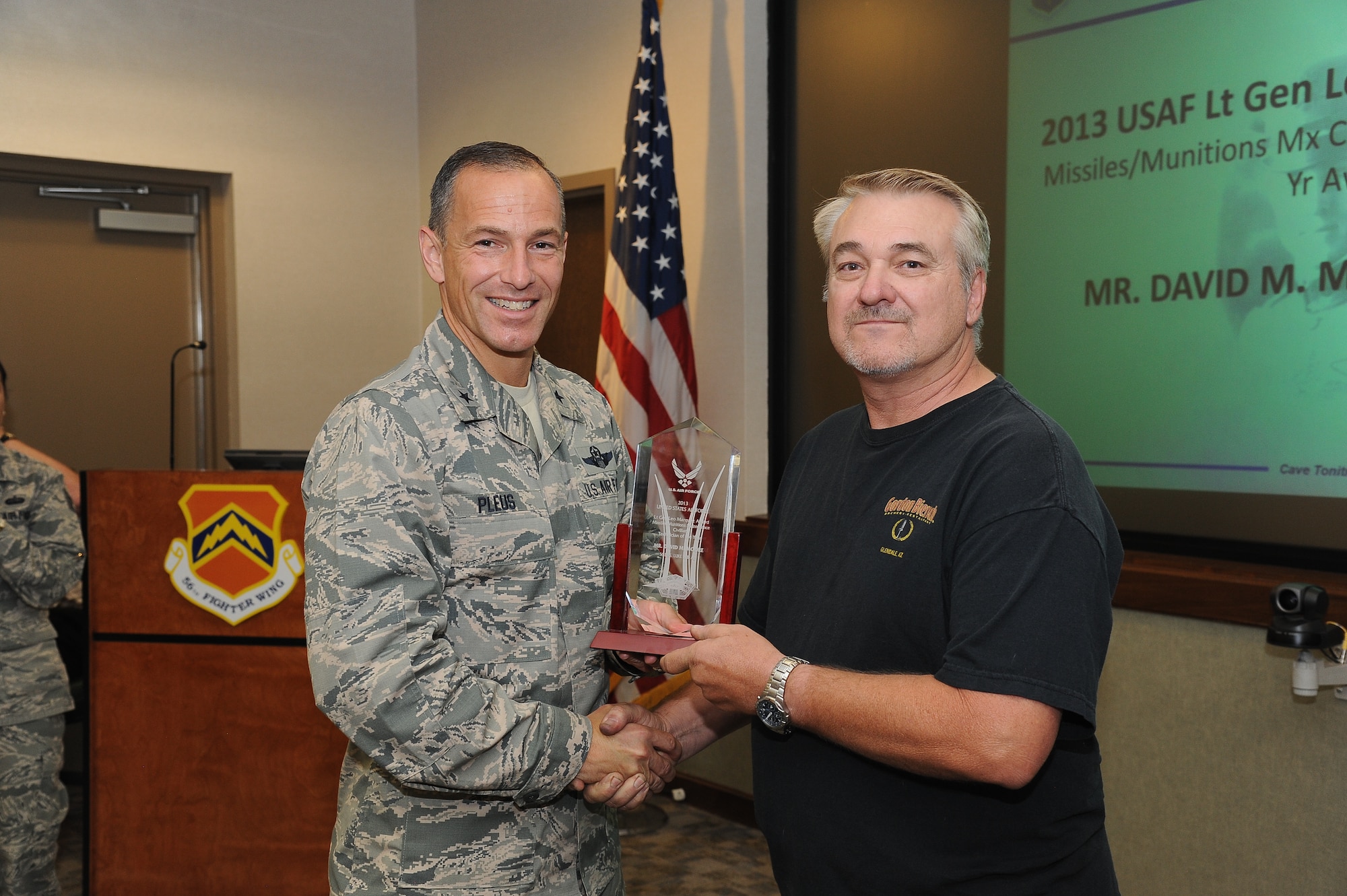 Brig. Gen. Scott Pleus, 56th Fighter Wing commander, presents David Moore, 56th Equipment Maintenance Squadron Aircraft Armament Systems technician, with the 2013 Air Force Lt. Gen. Leo Marquez Award for Outstanding Munitions/Missile Maintenance Person, civilian technician category at Luke Air Force Base July 22. Moore, a prior enlistee, has more than 20 years of experience working as a weapons loader and armament specialist. (U.S. Air Force photo/Airman 1st Class Pedro Mota)