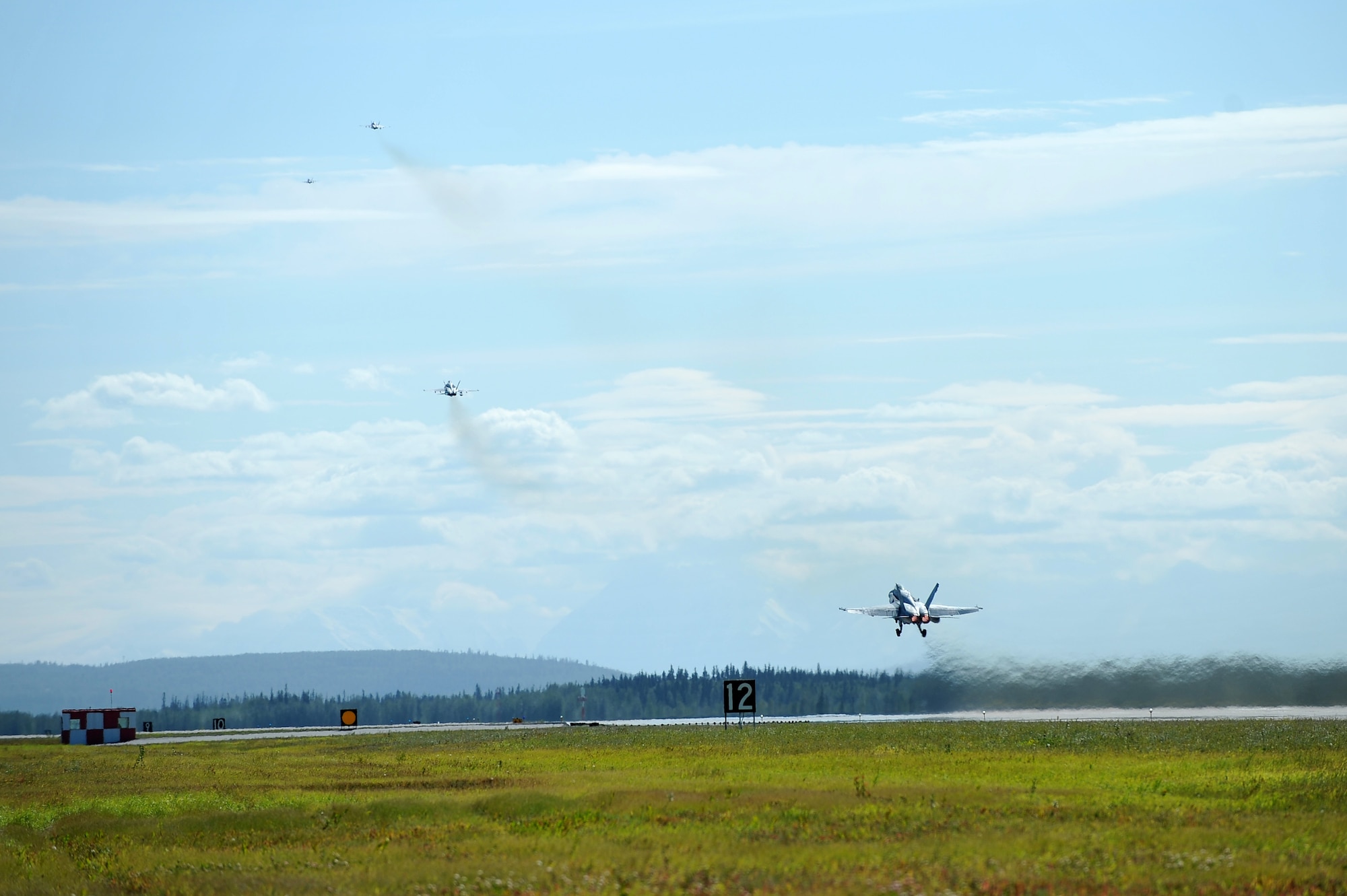 U.S. Marine Corps F/A-18 Hornets assigned to the Marine Fighter Attack Squadron 323, Marine Corps Air Station Miramar, Calif., take off during RED FLAG-Alaska 14-3 Aug. 8, 2014, Eielson Air Force Base, Alaska. RF-A is a multi-service, multi-national coordinated aerial combat operations exercise designed to test operational capabilities of participating units. (U.S. Air Force photo by Staff Sgt. Jim Araos/Released)