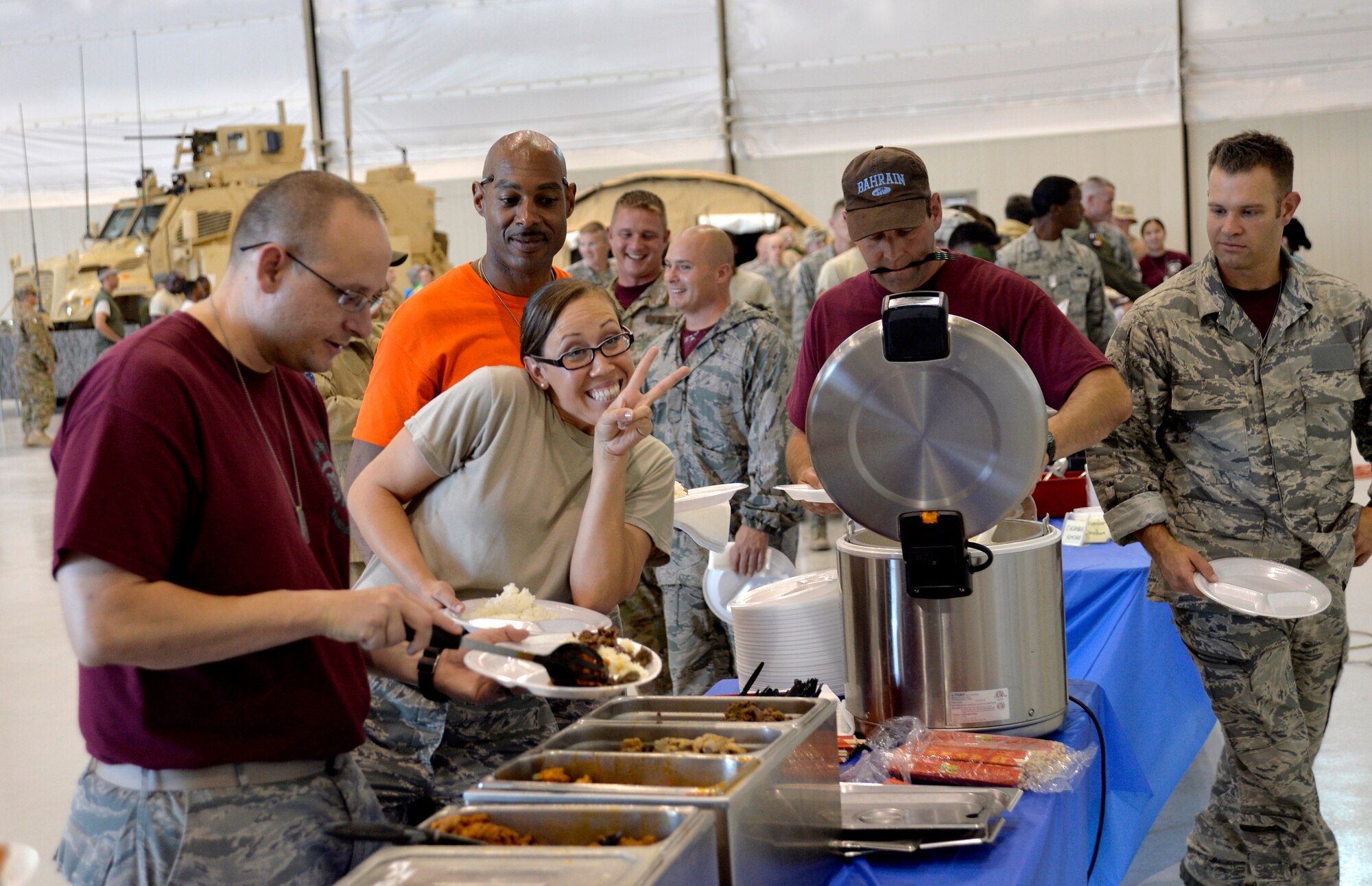 Airmen from the 432nd Wing get food for dinner as part of the first ever combat dining-in on Creech Air Force Base, Nev., July 11, 2014. The combat dining-in is an 84-year-old Air Force tradition which aims to enhance espirit de corps and build camaraderie with fellow Airmen. (U.S. Air Force photo by Airman 1st Class Christian Clausen/Released)