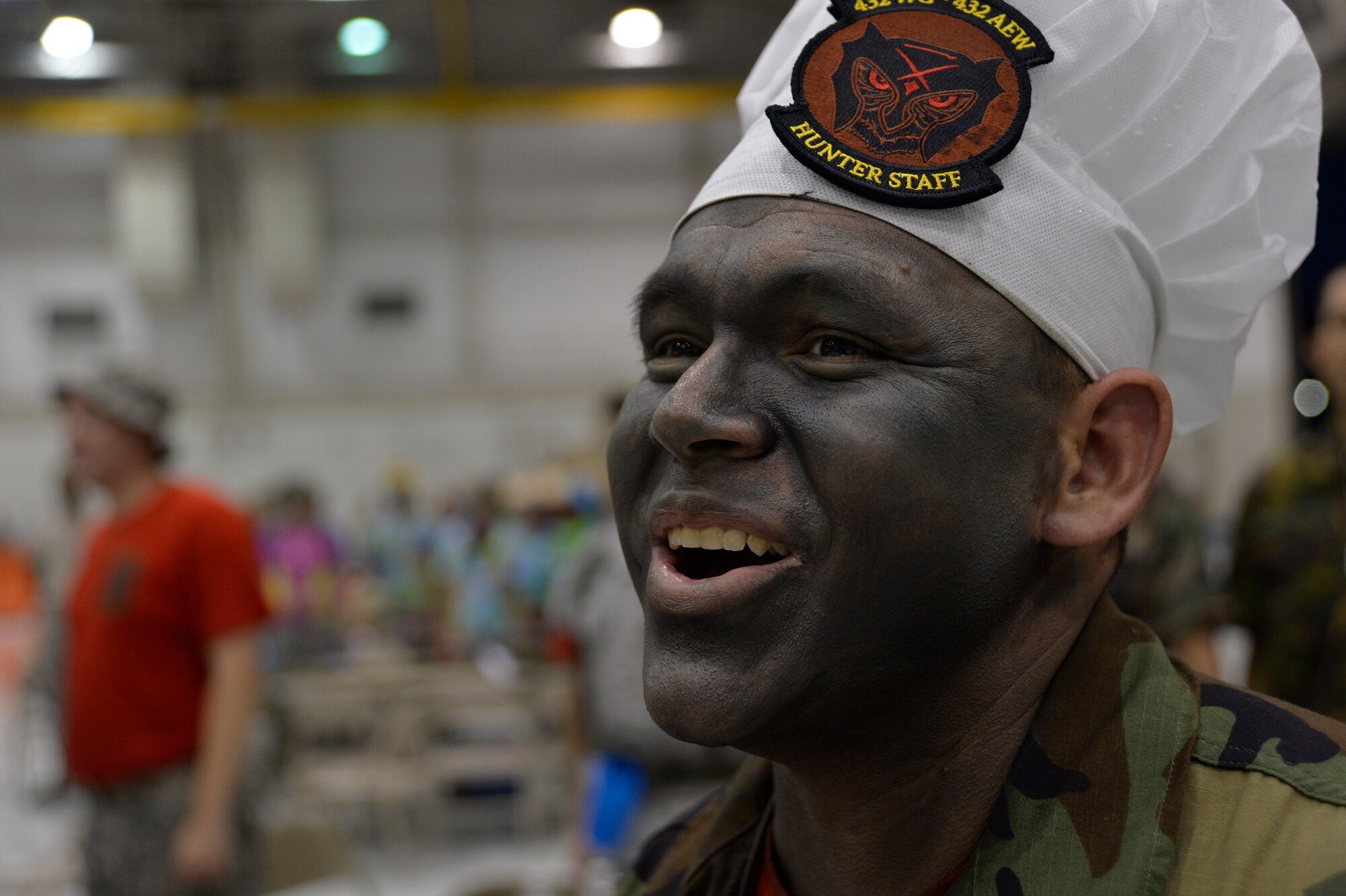 Staff Sgt. Daniel Villegas, 432nd Wing Protocol NCO in charge, laughs during the inaugural combat dining-in at Creech Air Force Base, Nev., July 11, 2014. During the event, participants were allowed to wear any combination of creatively revised past or present Air Force utility or combat uniforms. (U.S. Air Force photo by 1st Lt. Stephani Schafer/Released)
