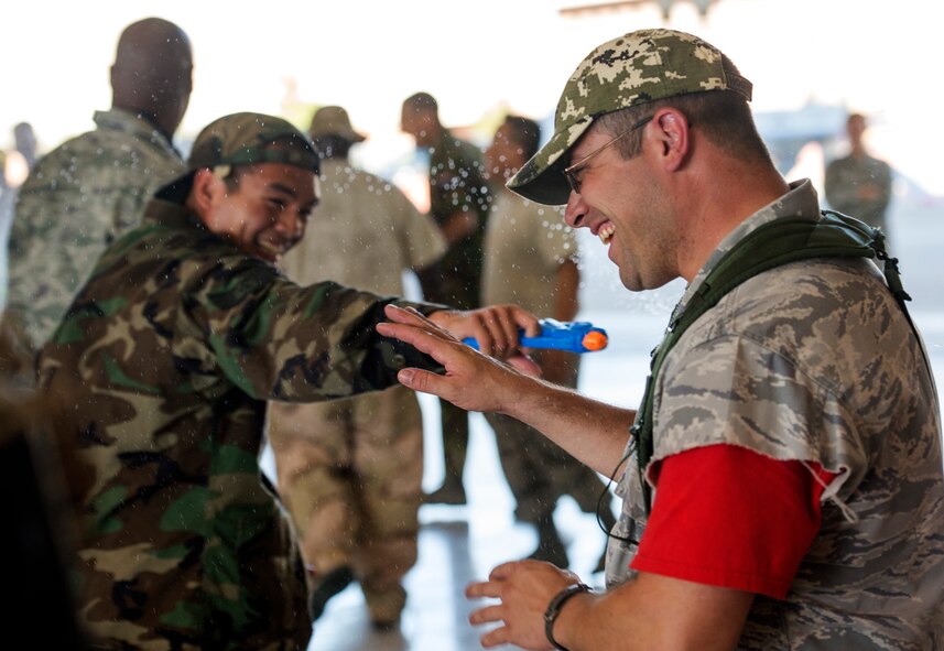 Tech. Sgt. Shad Eidson, 432nd Wing/432nd Air Expeditionary Wing Public Affairs craftsman, is shot by a water gun during the inaugural combat dining-in at Creech Air Force Base, Nev., July 11, 2014. Participants brought water balloons and water guns and engaged in friendly water “warfare” to help build camaraderie. (U.S. Air Force photo by 1st Lt. Stephani Schafer/Released)