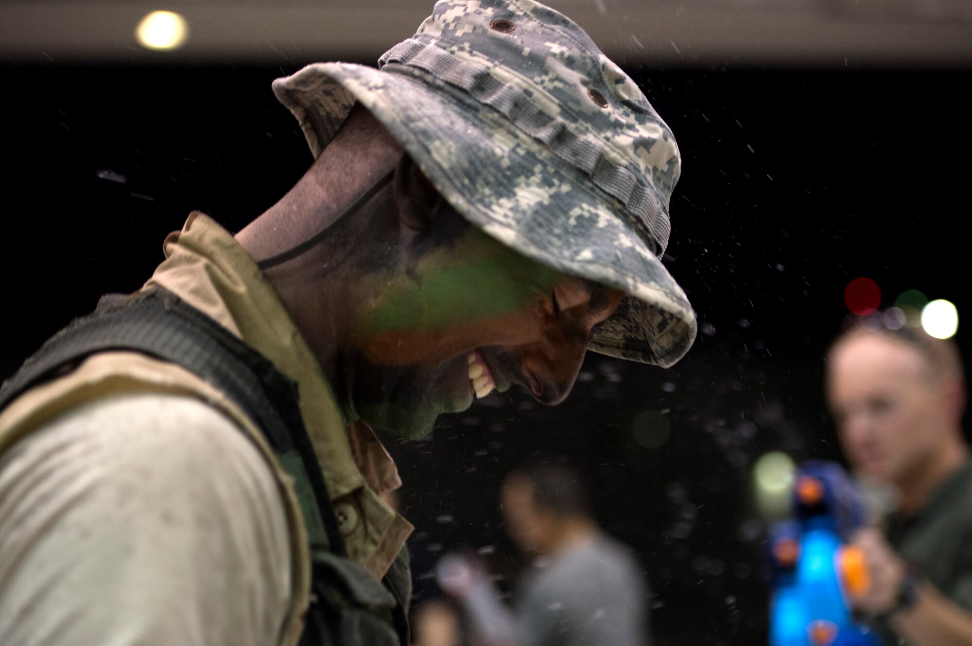 Airman 1st Class Christian Clausen, 432nd Wing/432nd Air Expeditionary Wing Public Affairs photojournalist apprentice, laughs while being shot by water guns during the first ever combat dining-in on Creech Air Force Base, Nev., July 11, 2014. Participants brought water balloons and water guns and engaged in friendly water “warfare” to help build camaraderie. (U.S. Air Force photo by 1st Lt. Stephani Schafer/Released)