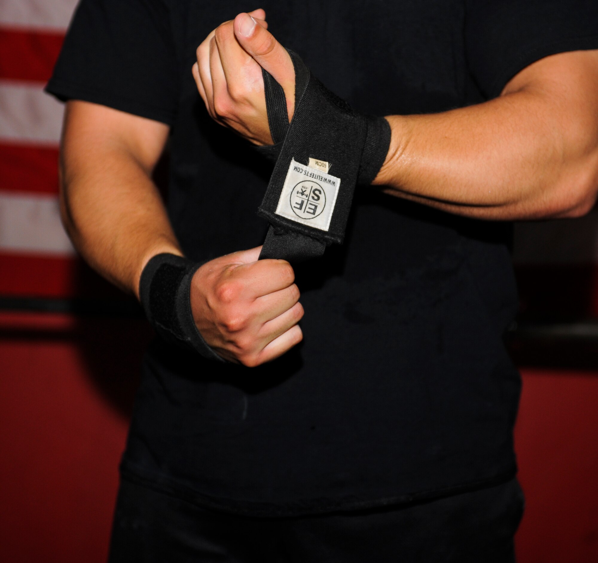 U.S. Air Force Staff Sgt. David Labrie, 612th Support Squadron lead meteorologist and powerlifter, wraps his wrists before lifting during a training session at a crossfit gym in Tucson, Ariz., Aug. 7, 2014. Labrie wraps his wrist to help strengthen them as well as give him the appropriate range of motion during each lift. (U.S. Air Force photo by Airman 1st Class Sivan Veazie/Released)