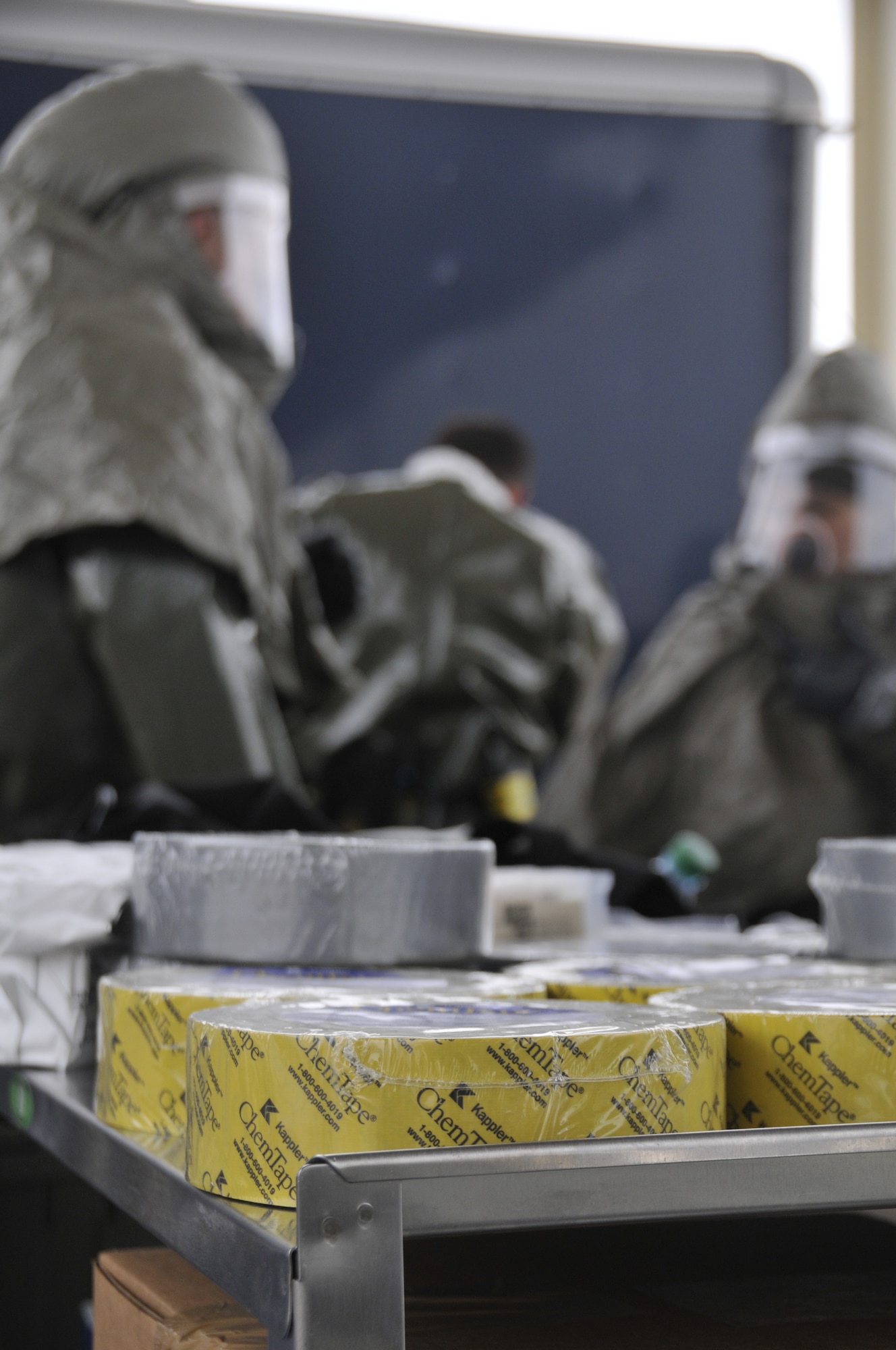 Airmen from the 188th Wing don protective gear during decontamination training at Ebbing Air National Guard Base, Arkansas, July 17. The volunteers, who were from various parts of the wing, learned how to set up a decontamination tent and clean victims of various chemical or nuclear hazards. This training will aid the wing in its mission to support Arkansas citizens in times of disaster. (U.S. Air National Guard photo by Staff Sgt. John Suleski/released)