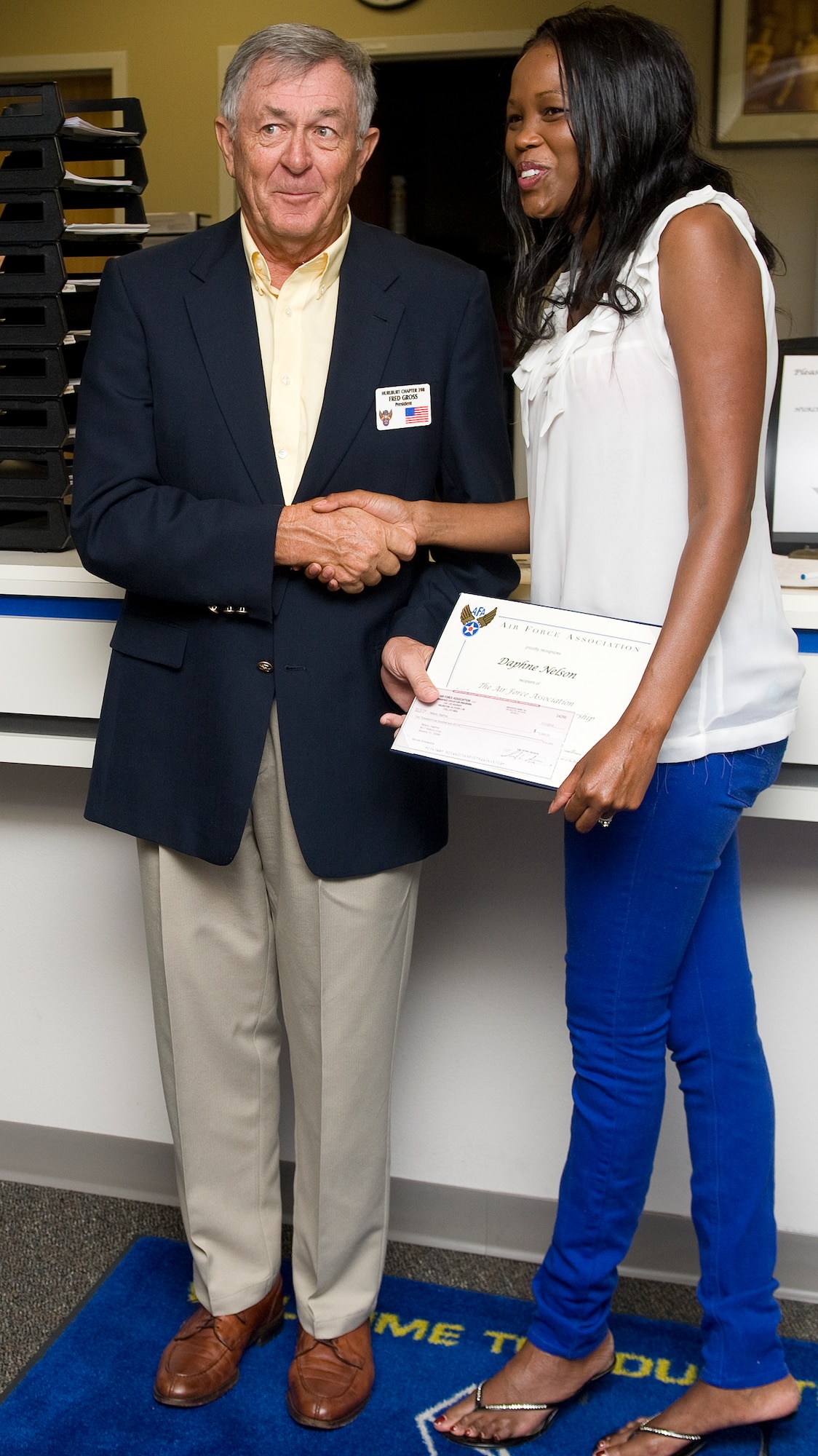 Fred Gross, local Air Force Association president, presents Daphne Nelson, 1st Special Operations Security Forces Squadron spouse, a check for $2,500 at the Education Center on Hurlburt Field, Fla., Aug. 6, 2014. The scholarship is the first in the Air Force to be made specifically for spouses of Air Force personnel (U.S. Air Force photo/Senior Airman Kentavist P. Brackin)