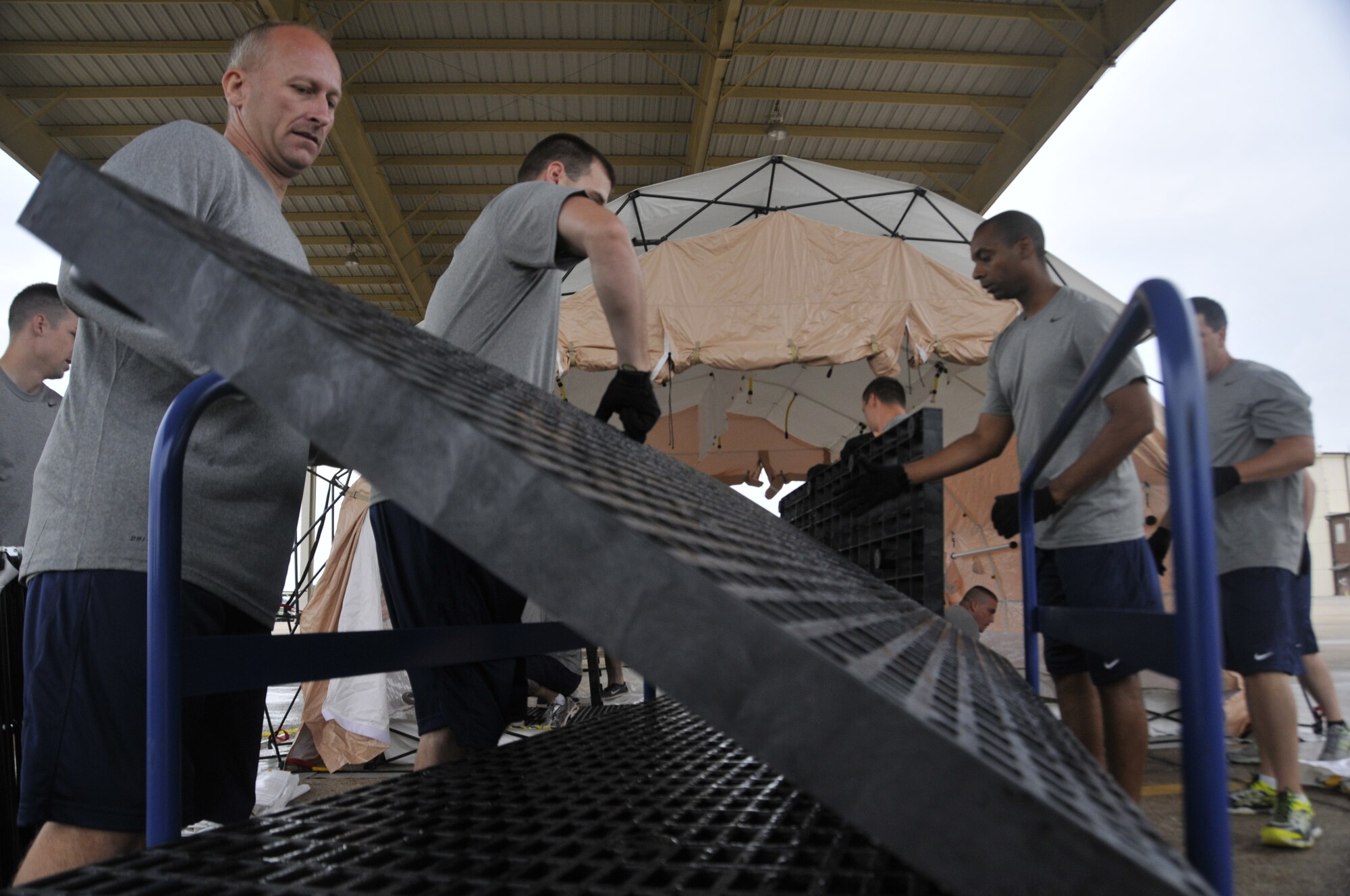 Airmen from the 188th Wing set up the flooring of a decontamination tent during a training event at Ebbing Air National Guard Base, Arkansas, July 17. The volunteers, who were from various parts of the wing, learned how to set up a decontamination tent and clean victims of various chemical or nuclear hazards. This training will aid the wing in its mission to support Arkansas citizens in times of disaster. (U.S. Air National Guard photo by Staff Sgt. John Suleski/released)