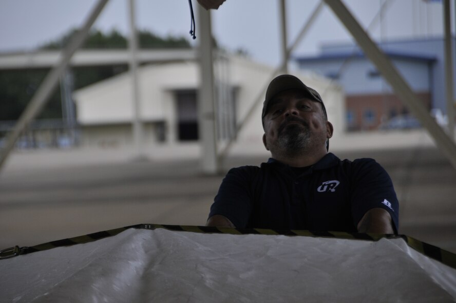 Alex Ibarra, Senior CBRN training specialist, demonstrates how to unfold a decontamination tent for Airmen from the 188th Wing during decontamination training at Ebbing Air National Guard Base, Arkansas, July 17. The volunteers, who were from various parts of the wing, learned how to set up a decontamination tent and clean victims of various chemical or nuclear hazards. This training will aid the wing in its mission to support Arkansas citizens in times of disaster. (U.S. Air National Guard photo by Staff Sgt. John Suleski/released)