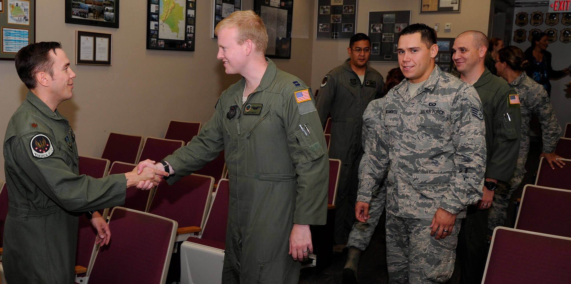Airmen from the 15th Special Operations Squadron congratulate Maj. Jeffery Taylor, 15th SOS MC-130H pilot, recipient of the Daedalian Exceptional Pilot of the Year for 2013 award Aug. 7, 2013 at the 15th SOS auditorium on Hurlburt Field, Fla. This prestigious award is presented annually to a pilot by the Air Force, and selection is based on exceptional deeds performed to assure mission success. (U.S. Air Force photo by Staff Sgt. Sarah Hanson)