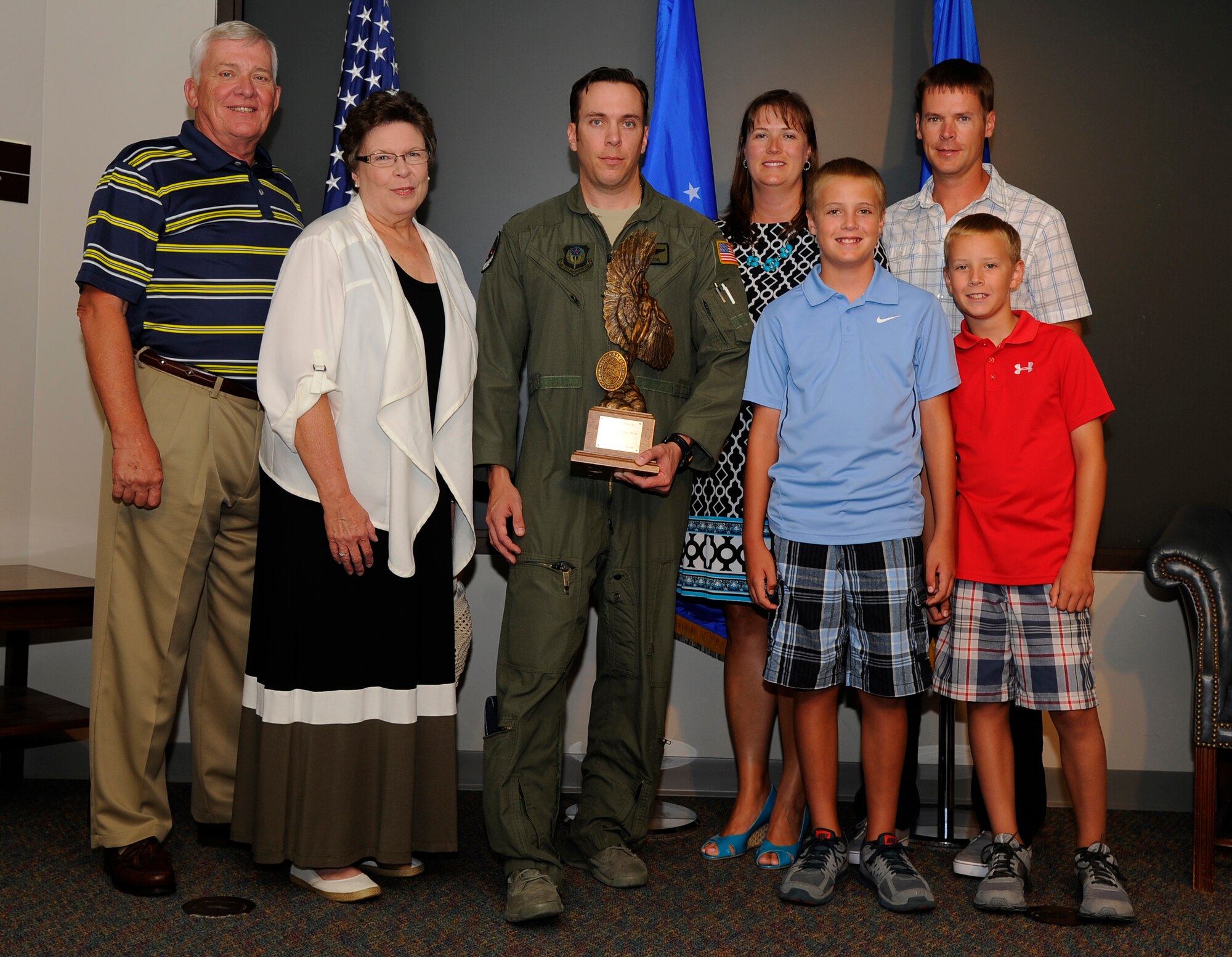 Maj. Jeffery Taylor, 15th Special Operations Squadron MC-130H pilot, stands with his family during an award presentation ceremony Aug. 7, 2014 at the 15th SOS auditorium on Hurlburt Field, Fla. Taylor received the Daedalian Exceptional Pilot of the Year for 2013 award for his courage and leadership in support of air operations throughout Afghanistan. (U.S. Air Force photo by Staff Sgt. Sarah Hanson)