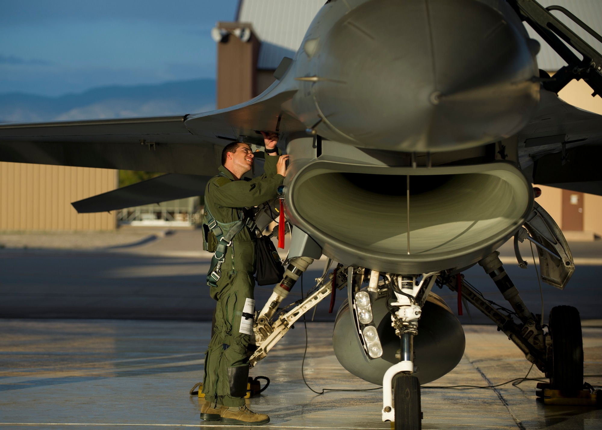 Captain Jake Pippenger, 54th Fighter Group pilot, inspects an F-16 Fighting Falcon to prepare for a training sortie over the White Sands Missile Range's 10,000 square mile range at Holloman Air force Base, N.M., Aug. 5. The 54th FG is a detachment of Luke AFB, Ariz., and is stationed on Holloman to facilitate high-speed training, live fire weapons training, and night flying operations. (U.S. Air Force photo by Airman 1st Class Leah Ferrante/Released)