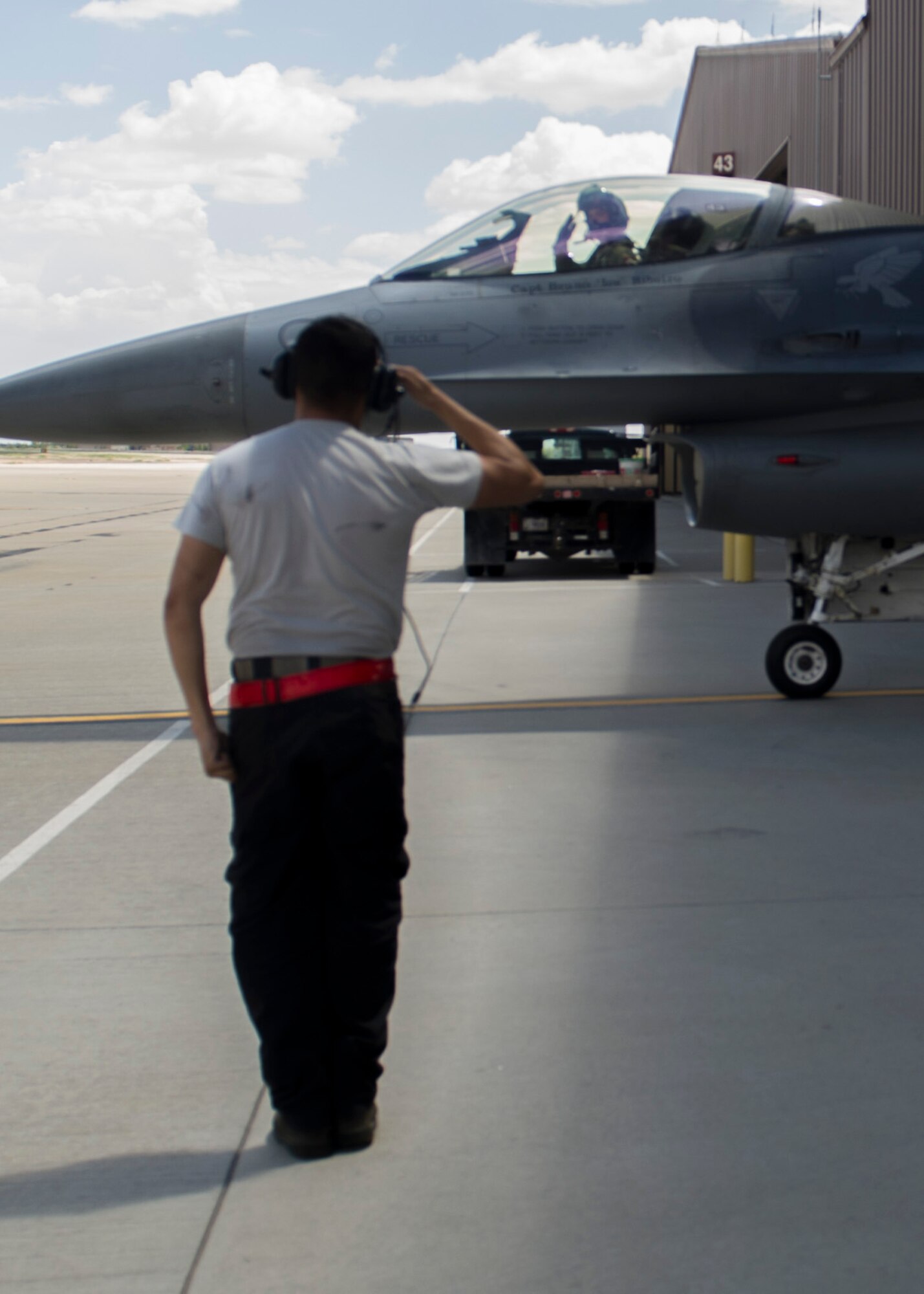 Senior Airman Ramiro Gamero, 311th Fighter Squadron crew chief, salutes Capt. John Widmer, 54th Fighter Group pilot, before a training sortie over the White Sands Missile Range's 10,000 square mile range at Holloman Air force Base, N.M., Aug. 5. The 54th FG is a detachment of Luke AFB, Ariz, and is stationed on Holloman to facilitate high-speed training, live fire weapons training, and night flying operations. (U.S. Air Force photo by Airman 1st Class Leah Ferrante/Released)