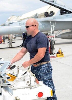 U.S. Navy Chief Warrant Officer 3 James Kelly, VFA 154 weapons officer, stands on the flightline before loading a munition Aug. 4, 2014, at Mountain Home Air Force Base, Idaho. More than 75 members of VFA 154, Naval Air Station Lemoore, Calif., are currently on temporary duty assignment here as a way to get combat training scenarios accomplished. (U.S. Air Force photo by Senior Airman Benjamin Sutton/Released)