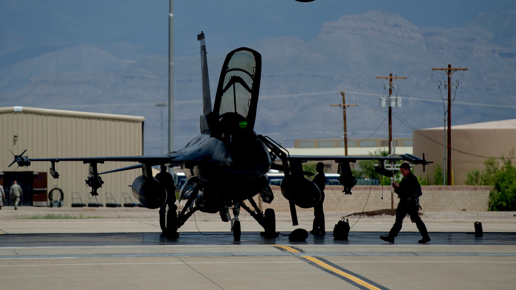 A pilot and crew chief from the 54th Fighter Group perform pre-flight checks prior to a training sortie over the White Sands Missile Range's 10,000 square mile range at Holloman Air Force Base, N.M., Aug. 5. The 54th FG is a detachment of Luke AFB, Ariz., and is stationed on Holloman to facilitate high-speed training, live fire weapons training, and night flying operations. (U.S. Air Force photo by Airman 1st Class Aaron Montoya / Released)