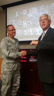 Daniel Sitterly, principal deputy assistant secretary of the Air Force for Manpower and Reserve Affairs, coins and thanks Capt. Andrew Williams, chief of Personnel Readiness Branch, for his leadership. Sitterly and John Fedrigo, deputy assistant secretary of the Air Force Reserve Affairs and Airman Readiness, visited with leaders and staff members at the Air Reserve Personnel Center at Buckley Air Force Base, Colo., Aug. 5. The intent of their visit was to identify areas that need to be reviewed today as well as to help plan for an Airman's future 30 years from now. (U.S. Air Force photo/Lt. Col. Belinda Petersen)