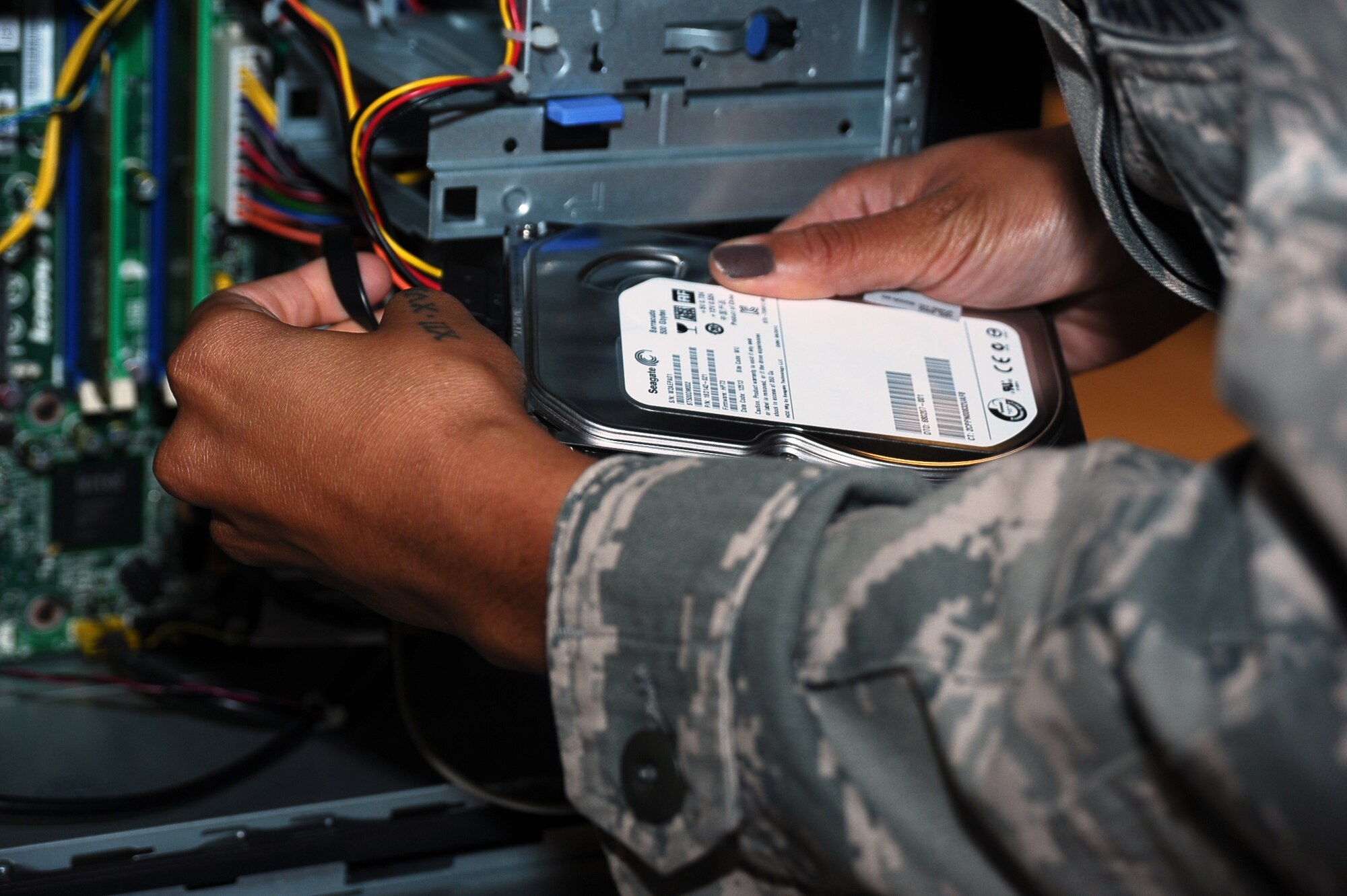 Senior Airman Jaquari Lopez, 14th Communications Squadron Client Service Operator, adds a new hard drive to a desktop computer so it may be reformatted Aug. 7 at Columbus Air Force Base. The squadron’s personnel plan, acquire, coordinate and integrate upgrades to communications and information infrastructure, as well as provide combat-ready personnel for mobility taskings. (U.S. Air Force photo/ Airman John Day)