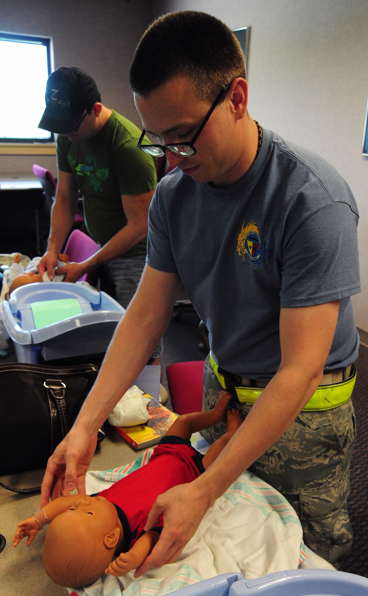 Senior Airman Adam Bairos, 509th Aircraft Maintenance Squadron electronic warfare journeyman, changes a baby doll’s diaper as part of a hands-on exercise for Dads the Basics at the Professional Development Center at Whiteman Air Force Base, Mo., July 18, 2014. Dads the Basics is a course that teaches soon-to-be fathers the fundamentals of caring for a baby. (U.S. Air Force photo by Staff Sgt. Nick Wilson/Released)