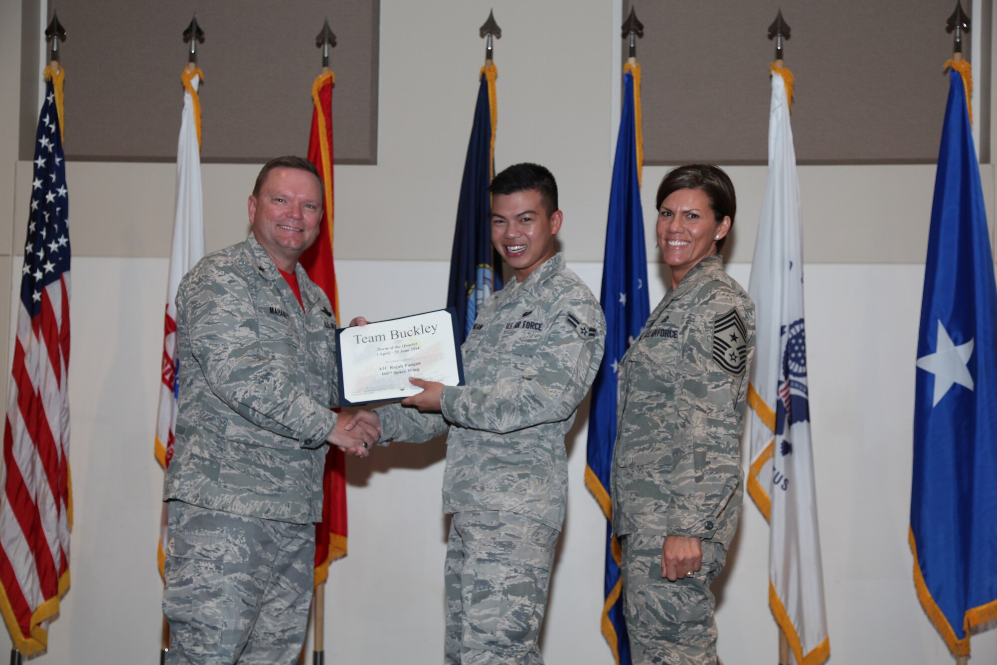Brig. Gen. Samuel "Bo" Mahaney, Air Reserve Personnel Center commander, and Chief Master Sgt. Ruthe Flores, ARPC command chief, present the Dormitory award to Airman 1st Class Rajah Pangan, 460th Space Wing, during the Team Buckley quarterly awards ceremony Aug. 8 on Buckley Air Force Base, Colo. (U.S. Air Force photo/Quinn Jacobson)