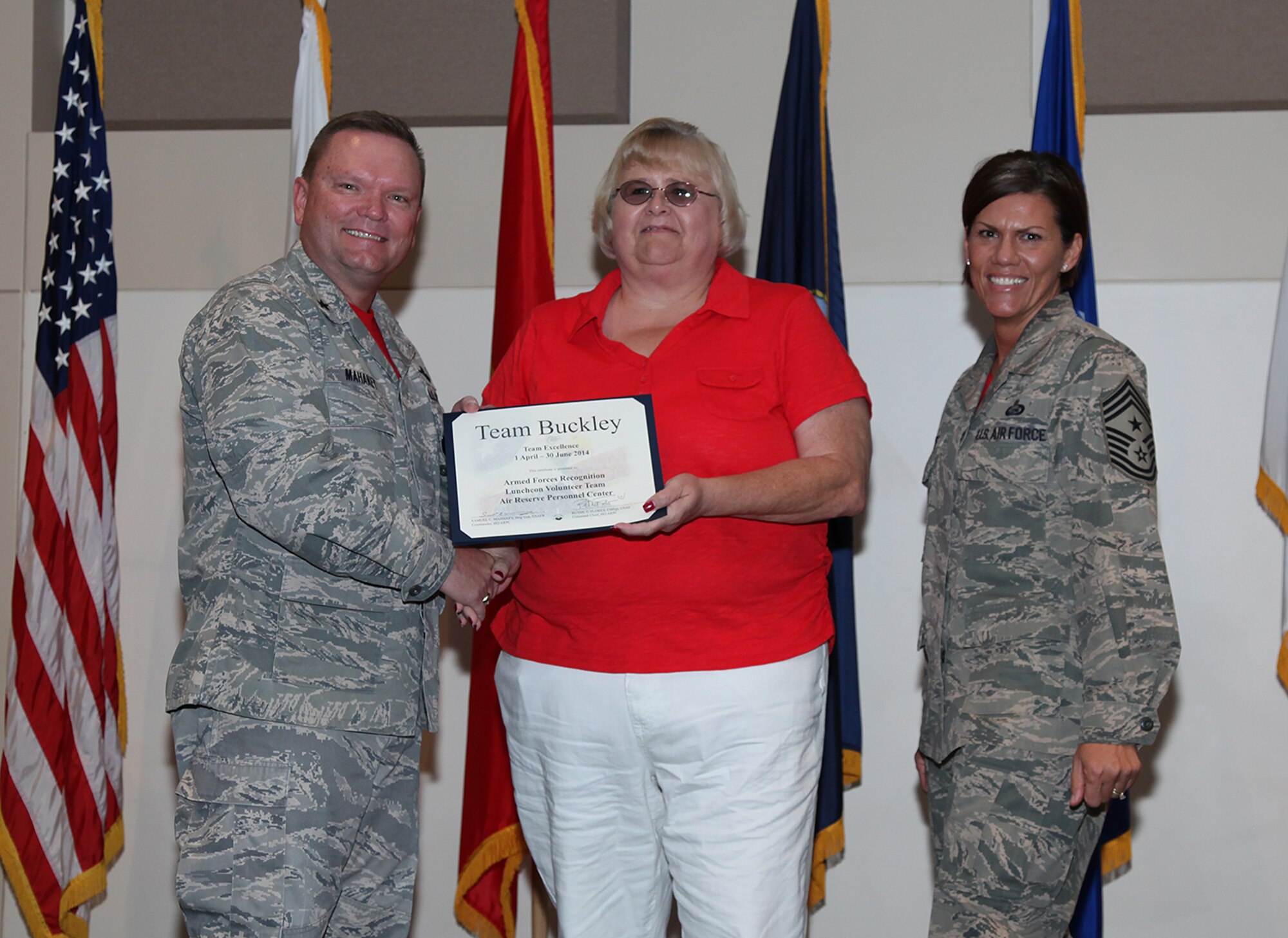 Brig. Gen. Samuel "Bo" Mahaney, Air Reserve Personnel Center commander, and Chief Master Sgt. Ruthe Flores, ARPC command chief, present the Team Excellence Award to Cindy Dewey, ARPC Armed Forces Recognition Luncheon Volunteer Team, during the Team Buckley quarterly awards ceremony Aug. 8 on Buckley Air Force Base, Colo. (U.S. Air Force photo/Quinn Jacobson)