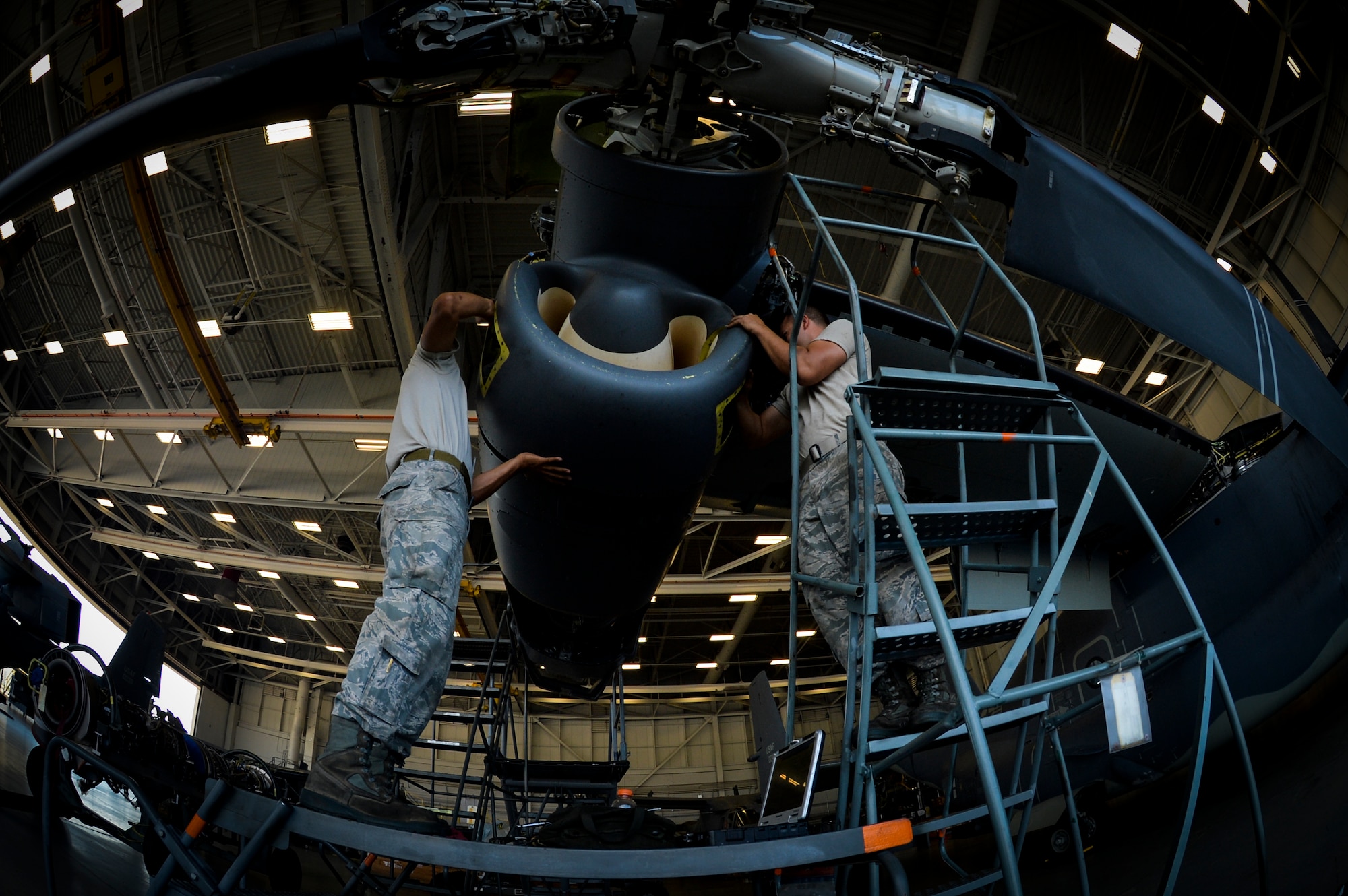 Senior Airman Richard Kodama, 8th Aircraft Maintenance Unit crew chief and Senior Airman Chad Pearsall, 8th AMU crew chief, work together to prepare a CV-22 Osprey engine for inspection on Hurlburt Field, Fla., Aug. 8, 2014. Crew chiefs ensure the Ospreys are mission ready for 8th Special Operations Squadron personnel. (U.S. Air Force photo/Senior Airman Christopher Callaway) 