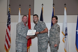 Brig. Gen. Samuel "Bo" Mahaney, Air Reserve Personnel Center commander, and Chief Master Sgt. Ruthe Flores, ARPC command chief, present the Junior Enlisted award to Senior Airman Jose Sanchez, 460th Space Wing, during the Team Buckley quarterly awards ceremony Aug. 8 on Buckley Air Force Base, Colo. (U.S. Air Force photo/Quinn Jacobson)
