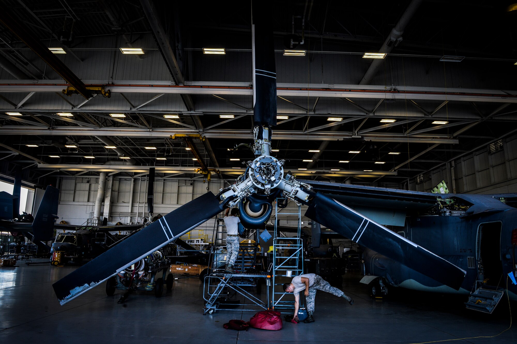 Airmen from the 801st Special Operations Aircraft Maintenance Squadron work on a CV-22 Osprey on Hurlburt Field, Fla., Aug. 8, 2014. The Osprey is a tilt-rotor aircraft, which allows it to hover and take off vertically in addition to transferring to high-speed horizontal flight. (U.S. Air Force photo/Senior Airman Christopher Callaway) 