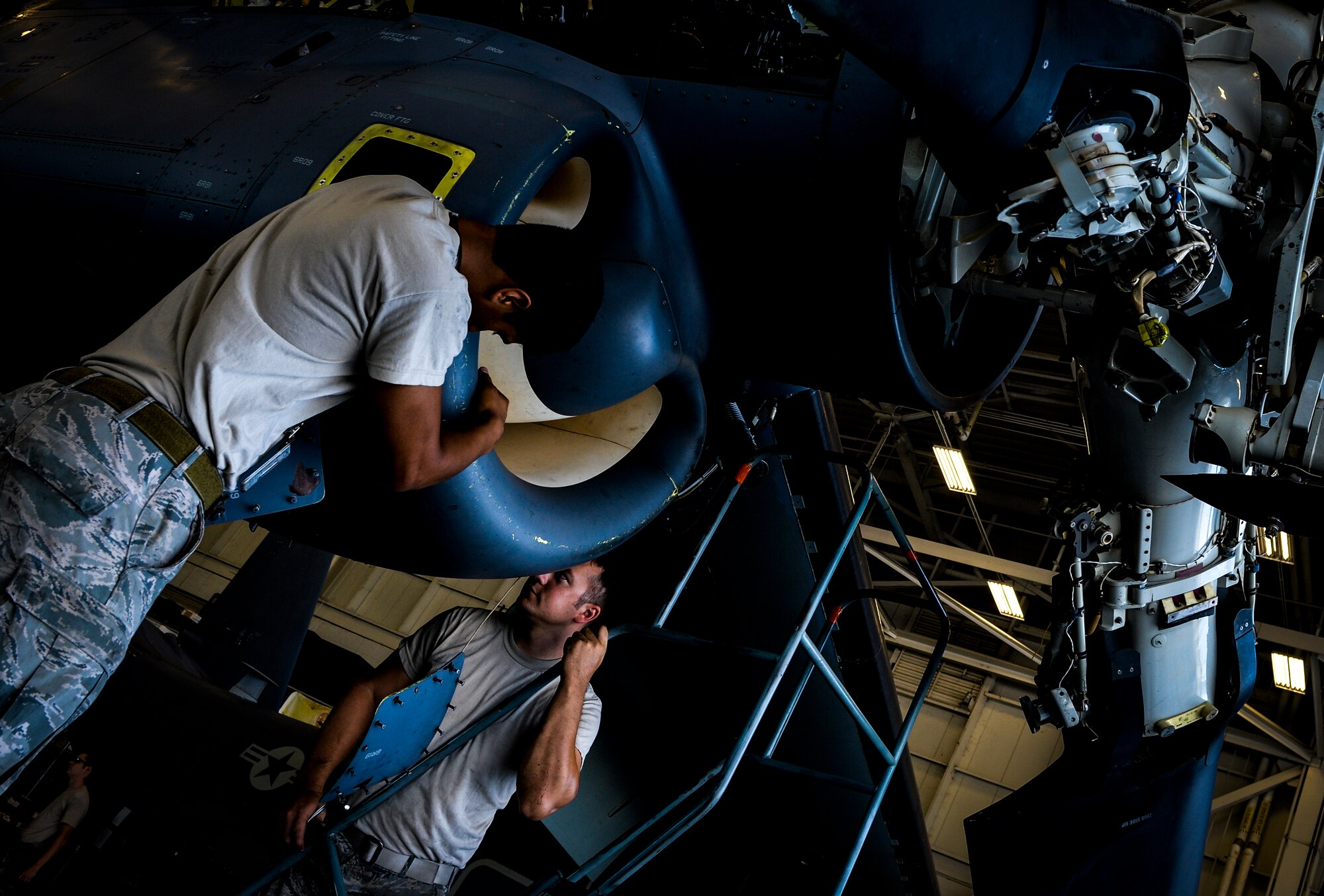 Senior Airman Richard Kodama, 8th Aircraft Maintenance Unit crew chief and Senior Airman Chad Pearsall, 8th AMU crew chief, work together to prepare a CV-22 Osprey engine for inspection on Hurlburt Field, Fla., Aug. 8, 2014. The 8th AMU is part of the 801st Special Operations Maintenance Squadron that performs all equipment maintenance in support of worldwide special operations missions. (U.S. Air Force photo/Senior Airman Christopher Callaway) 