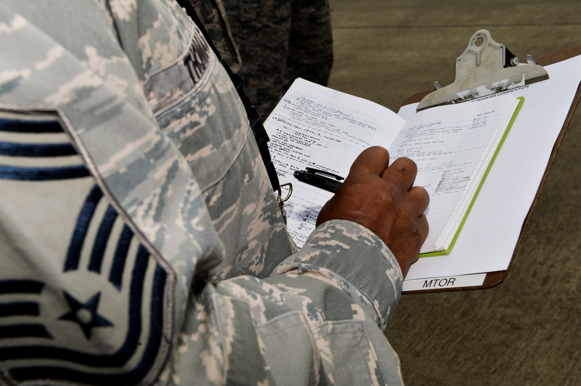 Chief Master Sgt. Raymond Thomas, 1st Special Operations Component Maintenance Squadron chief enlisted manager, takes notes during a Dedicated Crew Chief competition on Hurlburt Field, Fla., Aug. 1, 2014. Thomas was the dress and appearance judge for a DCC competition on base. (U.S. Air Force photo/Senior Airman Christopher Callaway) 