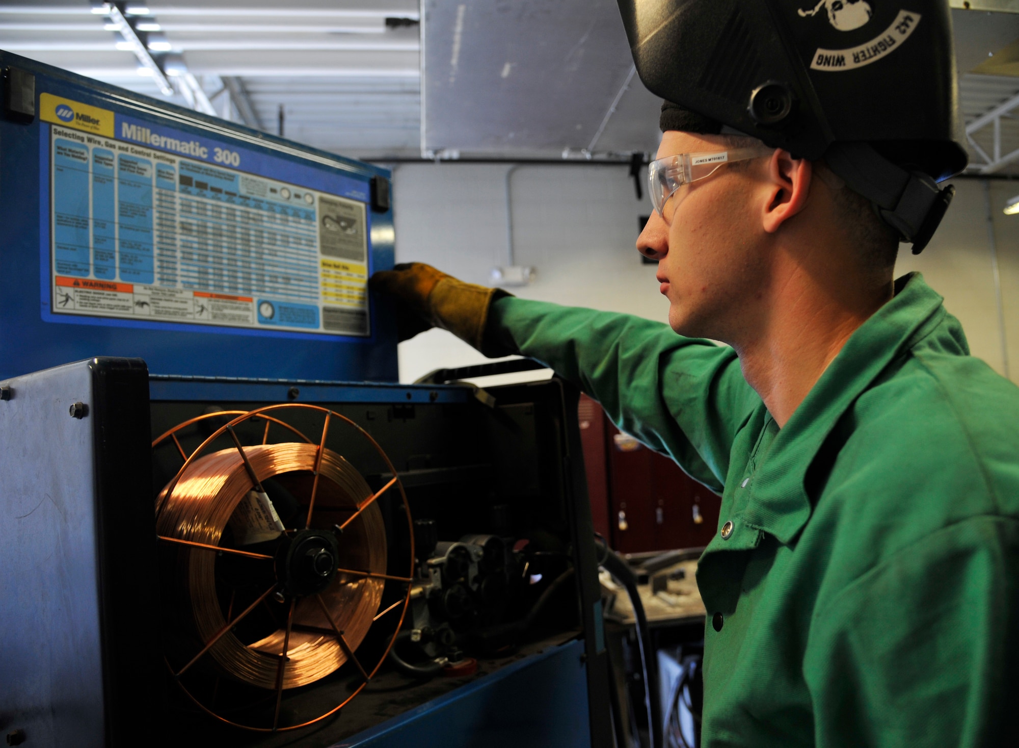 U.S. Air Force Senior Airman Mitchell Jones, 442nd Maintenance Squadron welder, examines chart on a wielding machine at Whiteman Air Force Base, Mo., July 16, 2014. The chart displays proper wielding settings for all metal used for wielding purpose. (U.S. Air Force photo by Airman 1st Class Keenan Berry/Released)