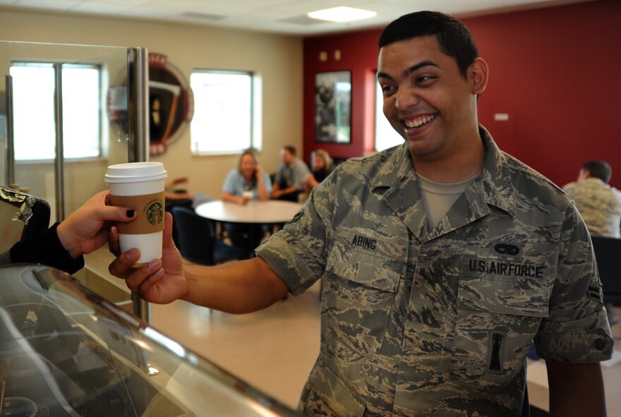 Airman 1st Class Aric Abing, 432nd Aircraft Maintenance Squadron weapons load crew member, buys a coffee from Coolbeans Cafe Aug. 7, 2014, at Creech Air Force Base, Nev. The new coffee shop is located in Building 1003 and will host a grand opening Aug. 12 at 8:30 a.m. (U.S. Air Force photo by Tech. Sgt. Shad Eidson/Released)