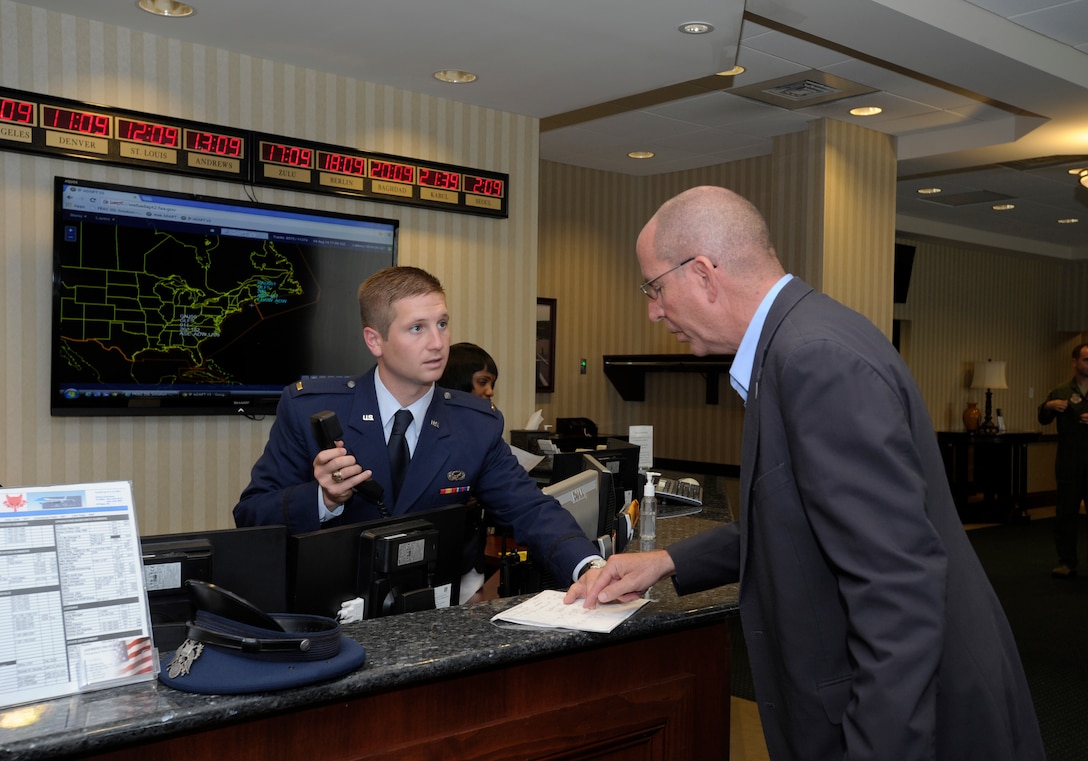 Second Lt. Zachary Sobeck, 89th Airlift Wing protocol officer, coordinates the servicing of aircraft for Mauritania and Guinea Bissau with John Polhemus, 89 AW foreign mission liaison, in the Distinguished Visitors Lounge on Joint Base Andrews flightline Aug. 4, 2014. Protocol, along with the 11th Wing Command Post and the FAA coordinated the arrival and servicing of more than two-dozen flights carrying national leaders en route to the US Africa Leaders Summit.  (U.S. Air Force photo/Senior Airman Kat Lynn Justen)