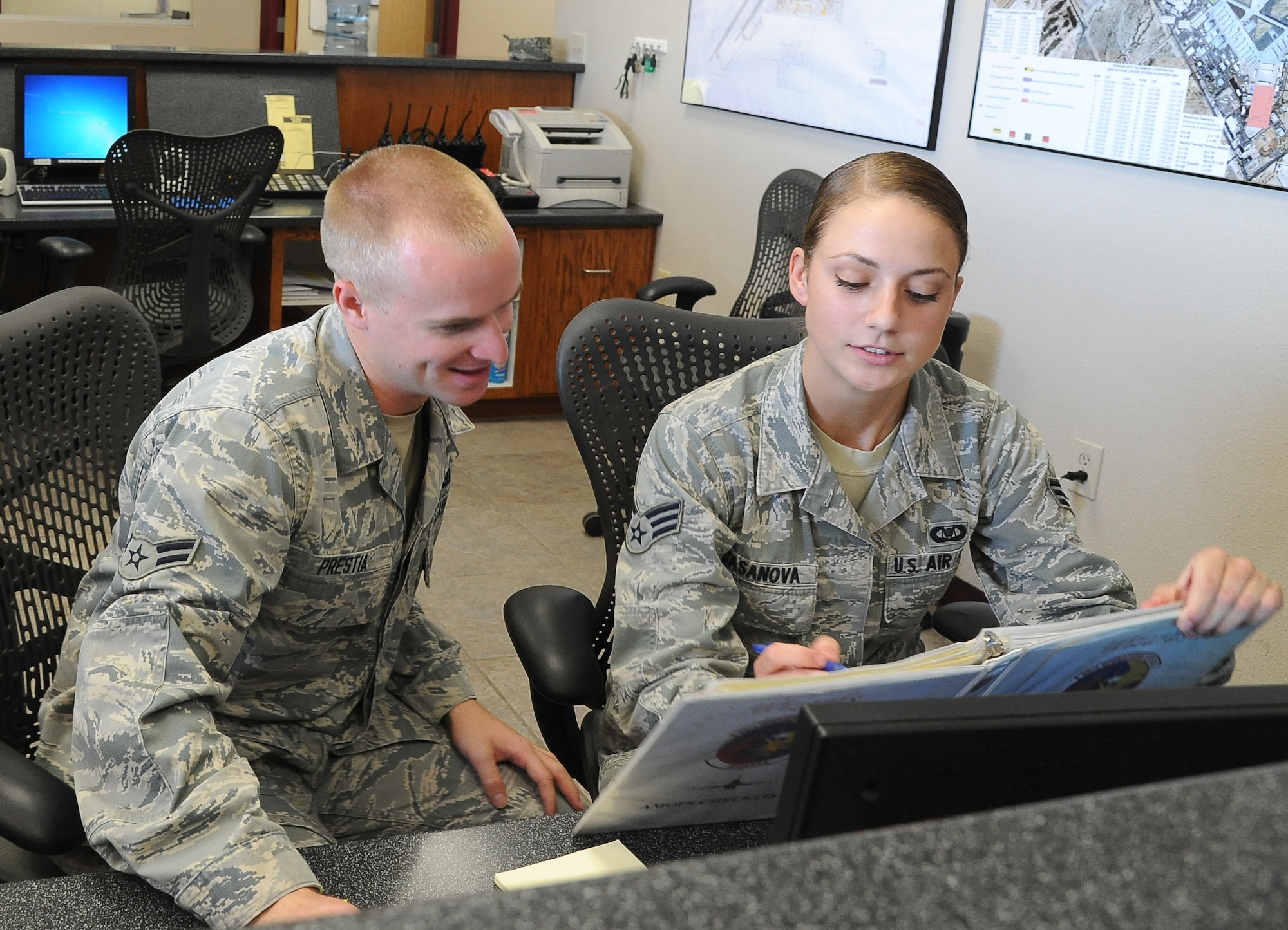 Airman 1st Class Delos Prestia, 56th Operations Support Squadron airfield management operations coordinator, and Senior Airman Monica Casanova, 56th OSS airfield management shift lead, work on an immigration checklist. (U.S. Air Force photo/Airman 1st Class Pedro Mota)