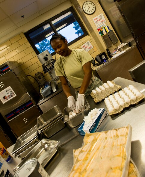 U.S. Air Force Airman 1st Class Neporsha Mobley, 23d Force Support Squadron services journeyman, places eggs into a pan at the Georgia Pines Dining Facility, Moody Air Force Base, Ga.,  Aug. 7, 2014. Mobley assists the other shifts by prepping certain foods and making it easier to keep up with the demand of feeding more than 450 Airmen daily.  (U.S. Air Force photo by Airman 1st Class Ceaira Tinsley/Released)