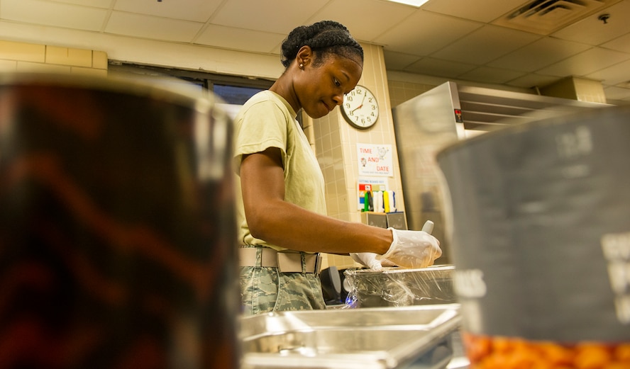 U.S. Air Force Airman 1st Class Neporsha Mobley, 23d Force Support Squadron services journeyman, marks the date and time on entrees at the Georgia Pines Dining Facility, Moody Air Force Base, Ga.,   Aug. 7, 2014. Mobley is tasked with prepping two entrees, starches, and vegetables for each meal to ensure Airmen are fed. (U.S. Air Force photo by Airman 1st Class Ceaira Tinsley/Released)