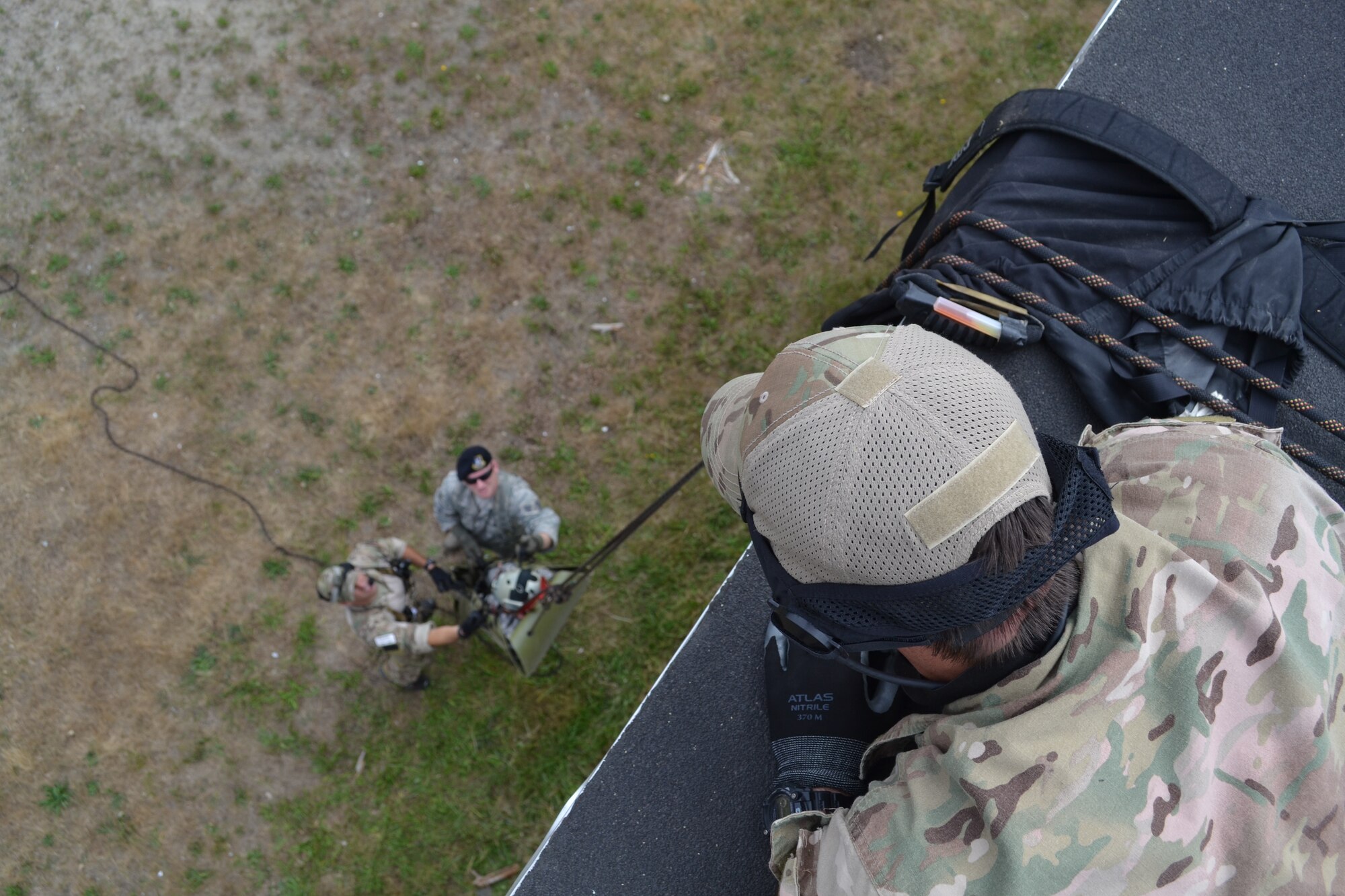 Staff Sgt. John Mellancamp, 304th Rescue Squadron, Portland International Air Guard Base, Ore., lowers a simulated casualty off a rooftop during Operation Pathfinder Minuteman at Camp Rilea, Ore., Aug. 5, 2014. Operation Pathfinder Minuteman was a joint disaster response exercise involving Air Force reservists, Air and Army National Guardsmen, and local, state federal civilian medical personnel. (U.S. Air Force photo/Staff Sgt. Daniel Delgado)