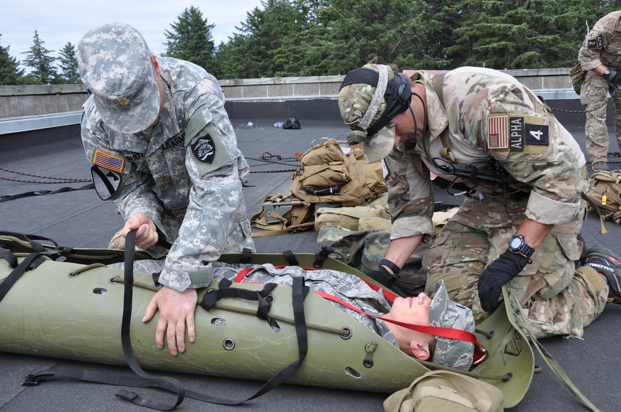 Senior Airman Kevin Dombey, a reserve pararescueman with the 304th Rescue Squadron, Portland Air National Guard Base, Ore., works alongside an Army National Guard medical provider to care for a simulated patient during Operation Pathfinder Minuteman Aug. 5, 2014 at Camp Rilea, Ore. Operation Pathfinder Minuteman was a joint disaster response exercise involving Air Force reservists, Air and Army National Guardsmen, and local, state federal civilian medical personnel. (U.S. Air Force photo/2nd Lt. Anna-Marie Wyant)