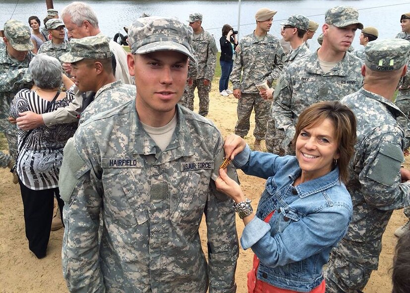 Senior Airman Austin Hairfield, 14th Air Support Operations Squadron tactical air control party member, poses as his mother, Melinda Harifield, pins his Ranger tab onto his uniform shortly after graduating from Army Ranger School. (Courtesy photo)