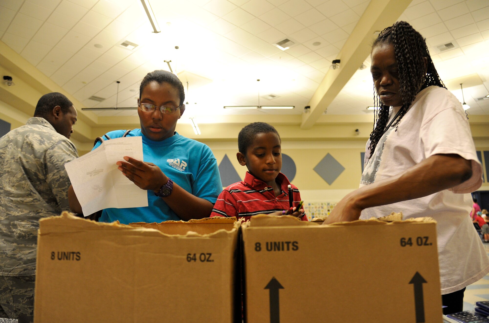 Ebelyn Stevenson and Suronda Stevenson help Jamiyln Stevenson pick out mechanical pencils during Operation Homefront’s Back-to-School Brigade in the Michael Anderson Elementary School gymnasium at Fairchild Air Force Base, Washington, Aug. 7, 2014. The organization provides service to military families across 43 states. (U.S. Air Force photo by Senior Airman Ryan Zeski/Released)