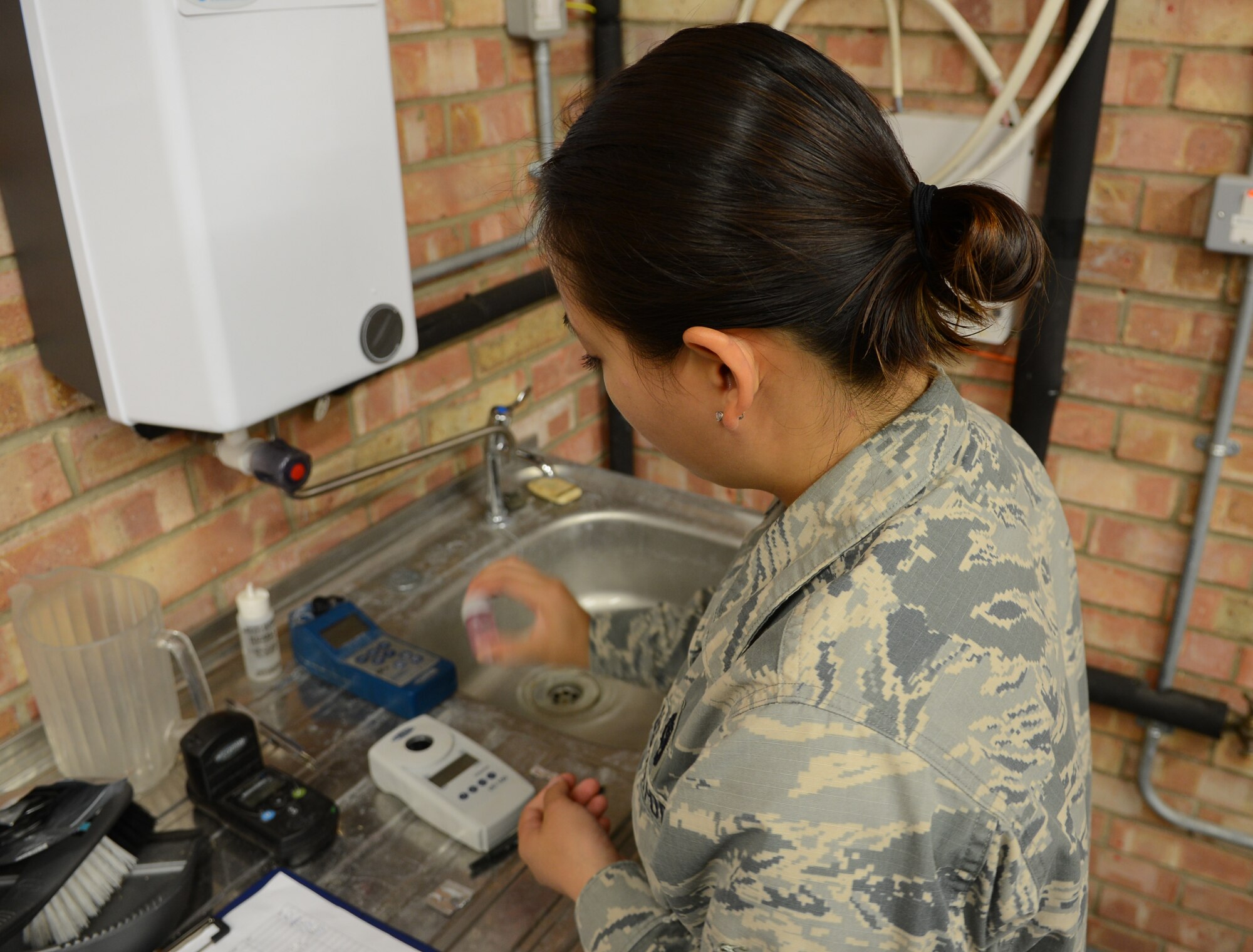 U.S. Air Force Airman 1st Class Thao Chau, 100th Civil Engineer Squadron water and fuels systems maintenance apprentice, tests a water sample for chlorine levels Aug. 7, 2014, on RAF Mildenhall, England. One of the responsibilities of the WFSM shop is to ensure the water on base is safe for consumption and use. (U.S. Air Force photo/Airman 1st Class Dillon Johnston/Released)