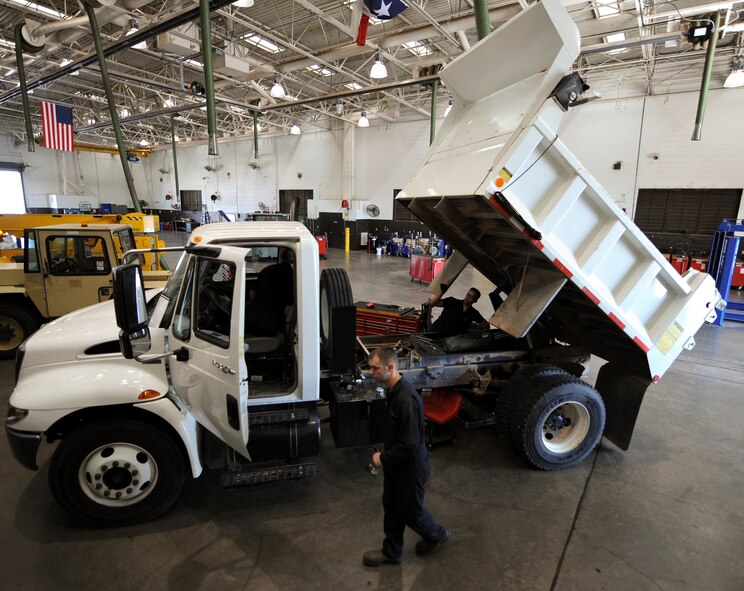 U.S. Air Force Airmen from the 7th Logistics Readiness Squadron perform maintenance on a dump truck Aug. 7, 2014, at Dyess Air Force Base, Texas. The truck needed repair due to a faulty hydraulic cylinder. (U.S. Air Force photo by Airman 1st Class Kedesha Pennant/Released)