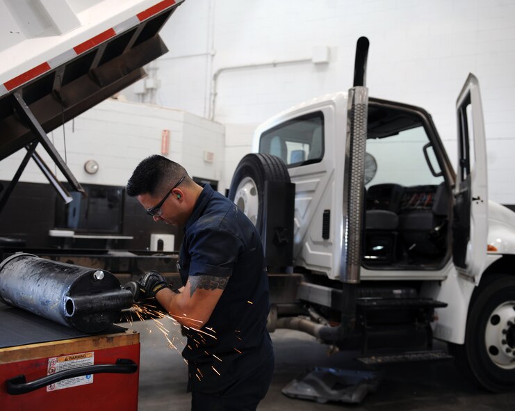 U.S. Air Force Airman 1st Class Jorge Diehl, 7th Logistics Readiness Squadron vehicle maintenance apprentice, grinds a weld on a hydraulic cylinder Aug. 5, 2014, at Dyess Air Force Base, Texas. This task is completed in order to properly reinstall the cylinder. The vehicle maintenance section has completed more than 10,000 repairs from more than 1,400 work orders in the past year. (U.S. Air Force photo by Airman 1st Class Kedesha Pennant/Released)