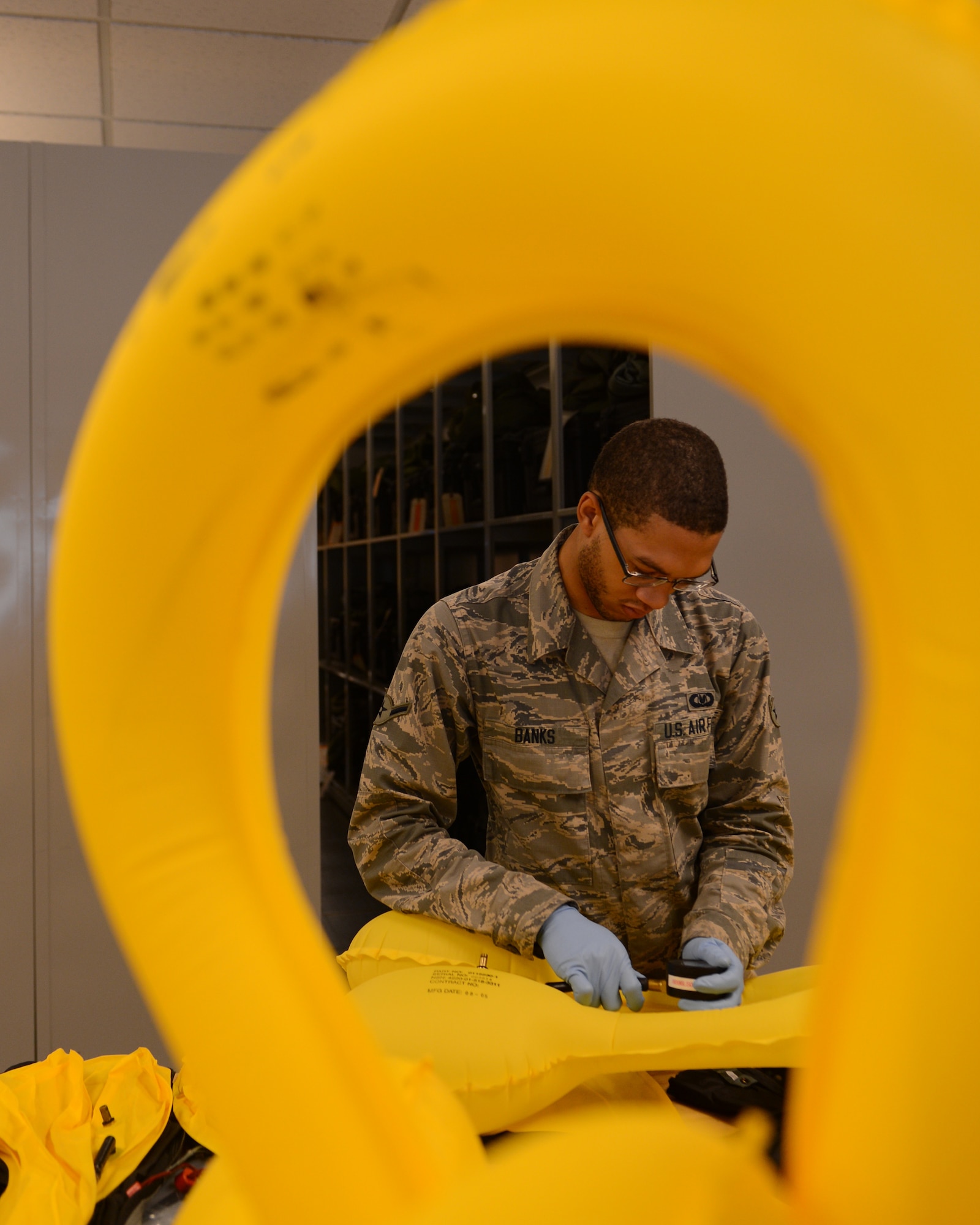 Airman Michael Banks, 2nd Operations Support Squadron Aircrew Flight Equipment helmet section, checks the pressure of a floatation device on Barksdale Air Force Base, La., Aug. 4, 2014. After inflating and checking the pressure of the unit, AFE Airmen will check the pressure again an hour later to ensure it has stayed at the same pressure. (U.S. Air Force photo/Senior Airman Benjamin Gonsier)